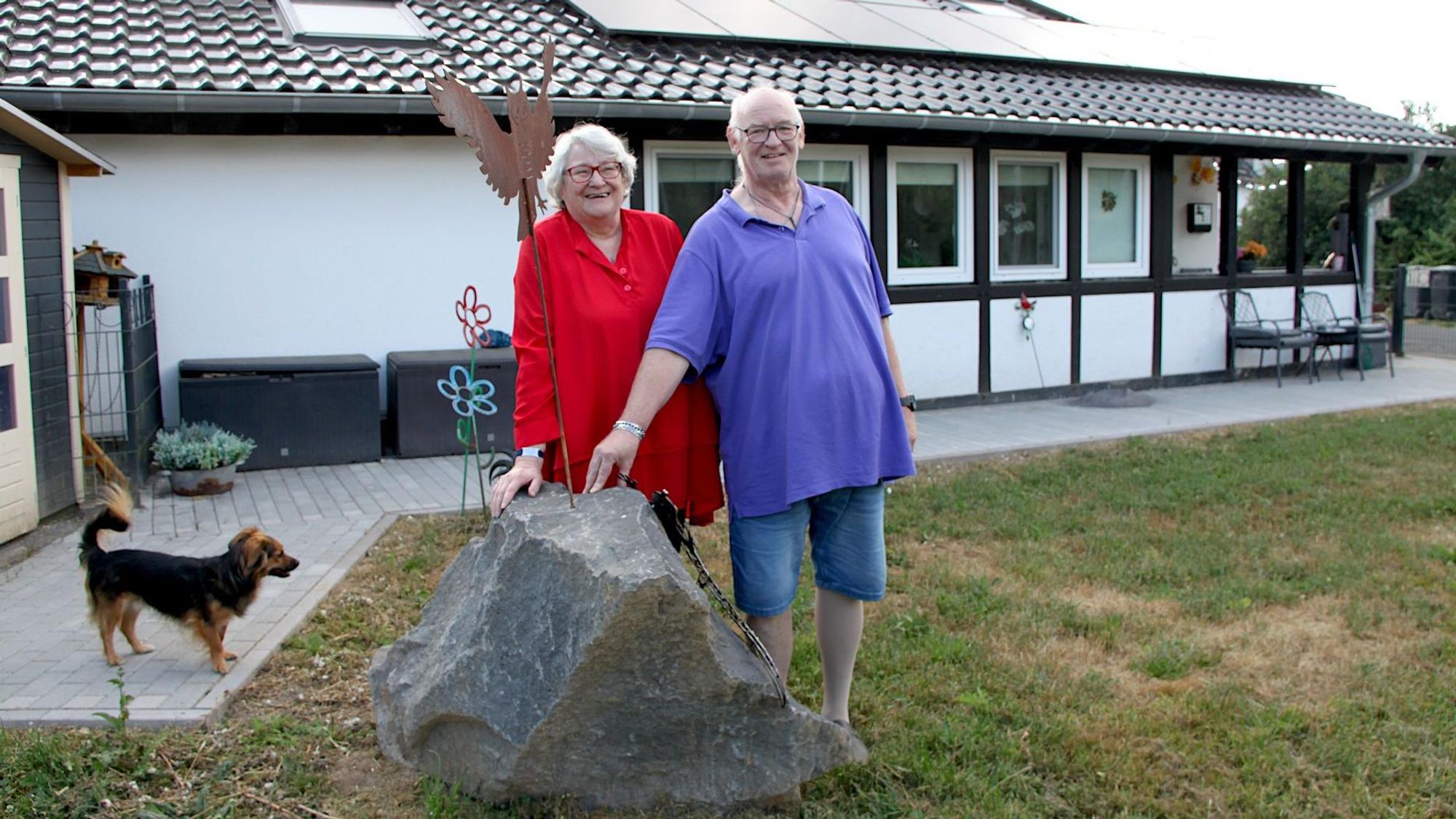 Die Eheleute Wirtz stehen mit ihrem Hund an einem großen Basaltblock. Im Hintergrund ist das neu errichtete Haus zu sehen.
