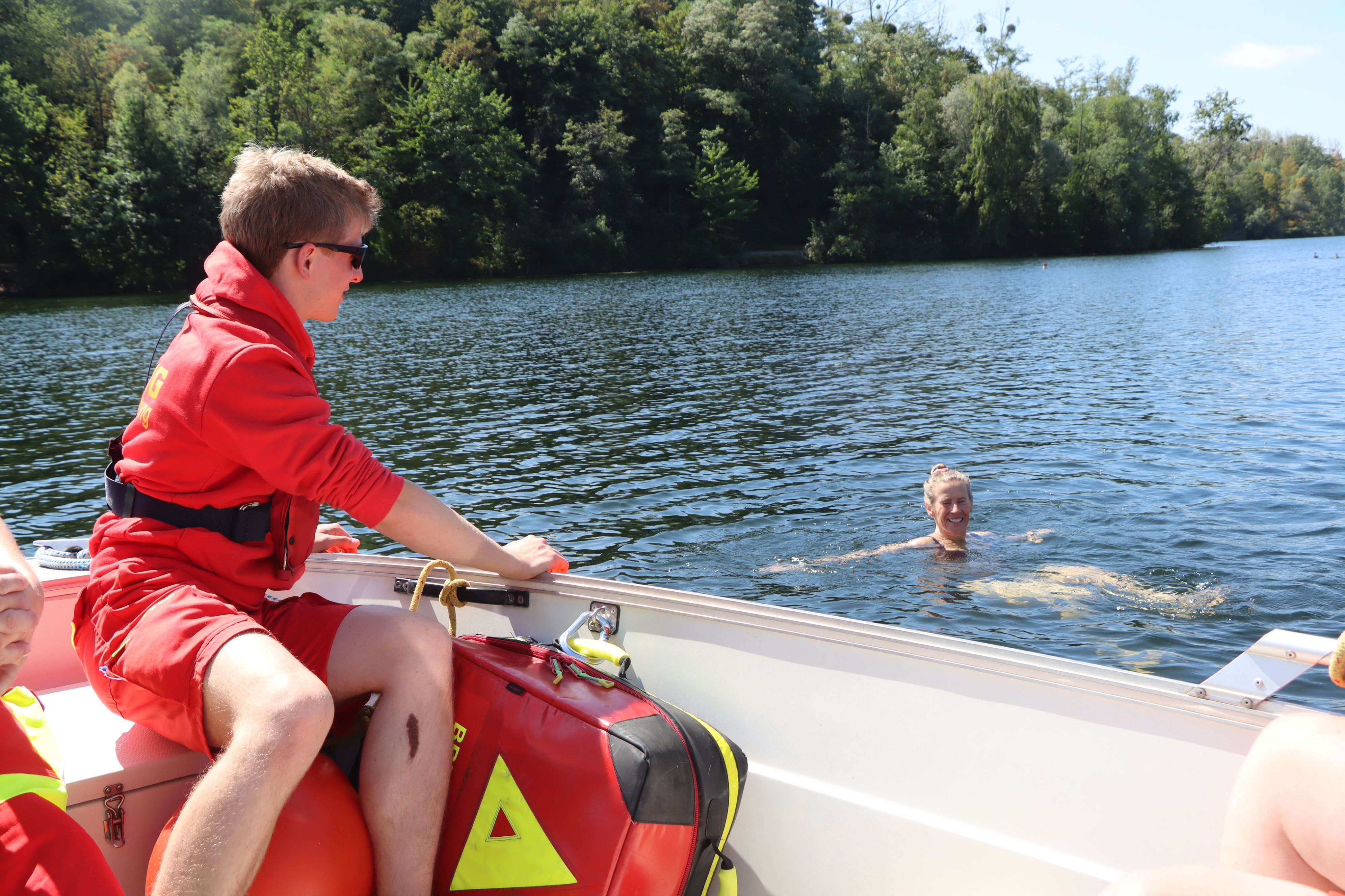 Das Bild zeigt eine Schwimmerin, die von einem DLRG-Mitarbeiter angesprochen wird.