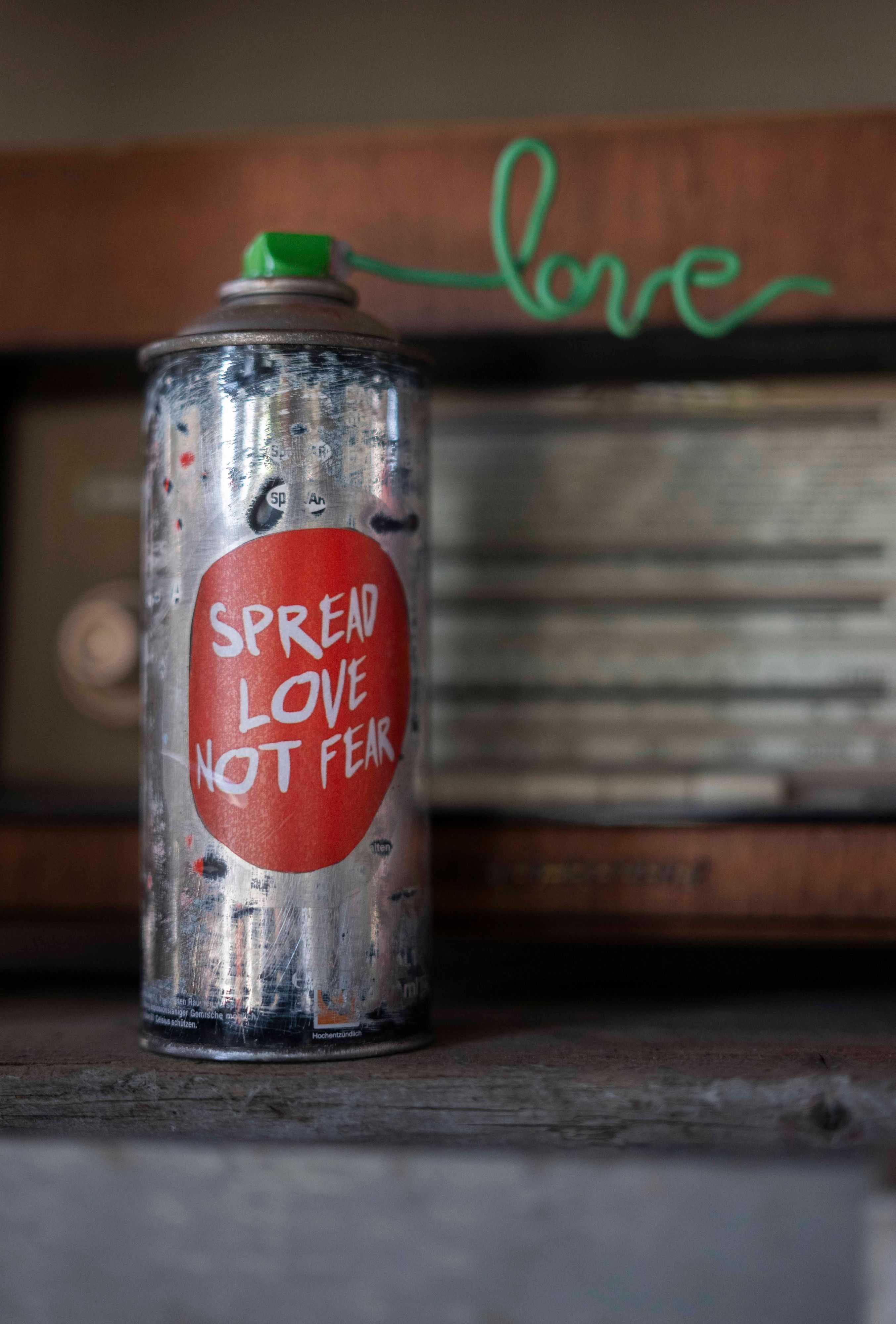 Auf einer Farbdose steht der Spruch: „Spread Love not Fear“.