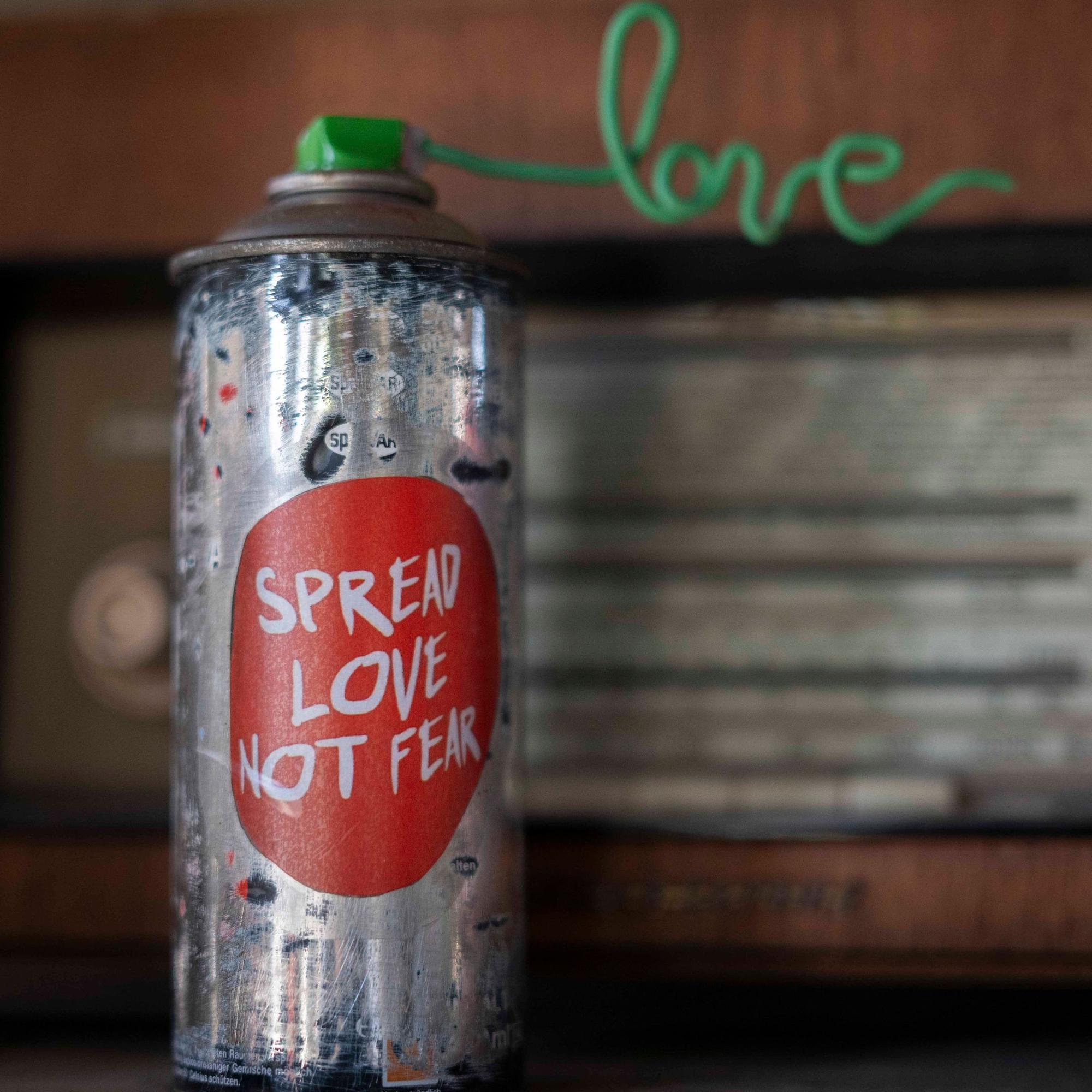 Auf einer Farbdose steht der Spruch: „Spread Love not Fear“.