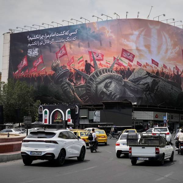 Teheran: Eine Plakatwand, auf der eine umgestürzte Freiheitsstatue und Menschenmengen mit iranischen und schiitischen Flaggen zu sehen sind.