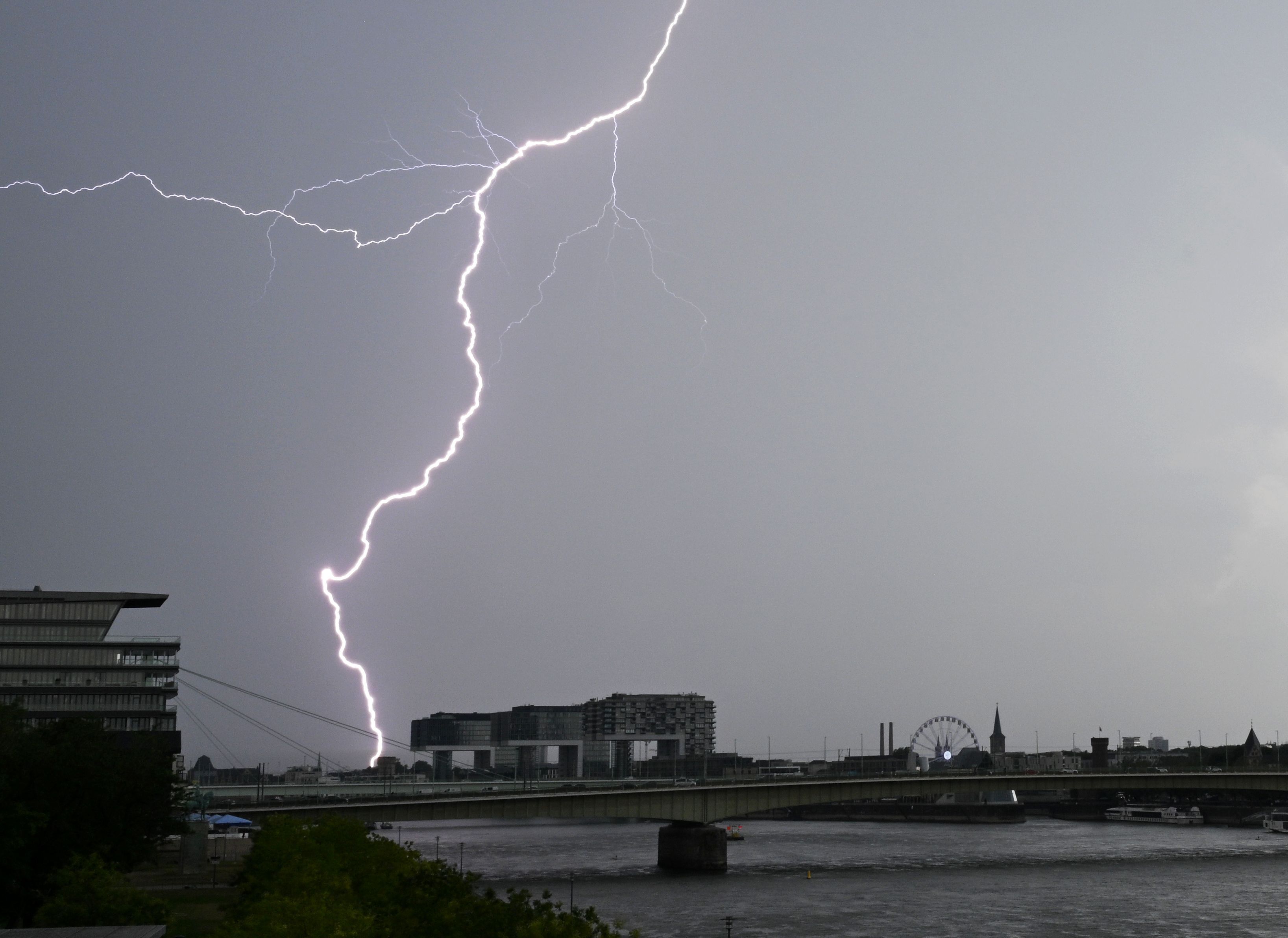 Ein Blitz zuckt bei einem Gewitter über dem Himmel über dem Kölner Süden (Archivbild).