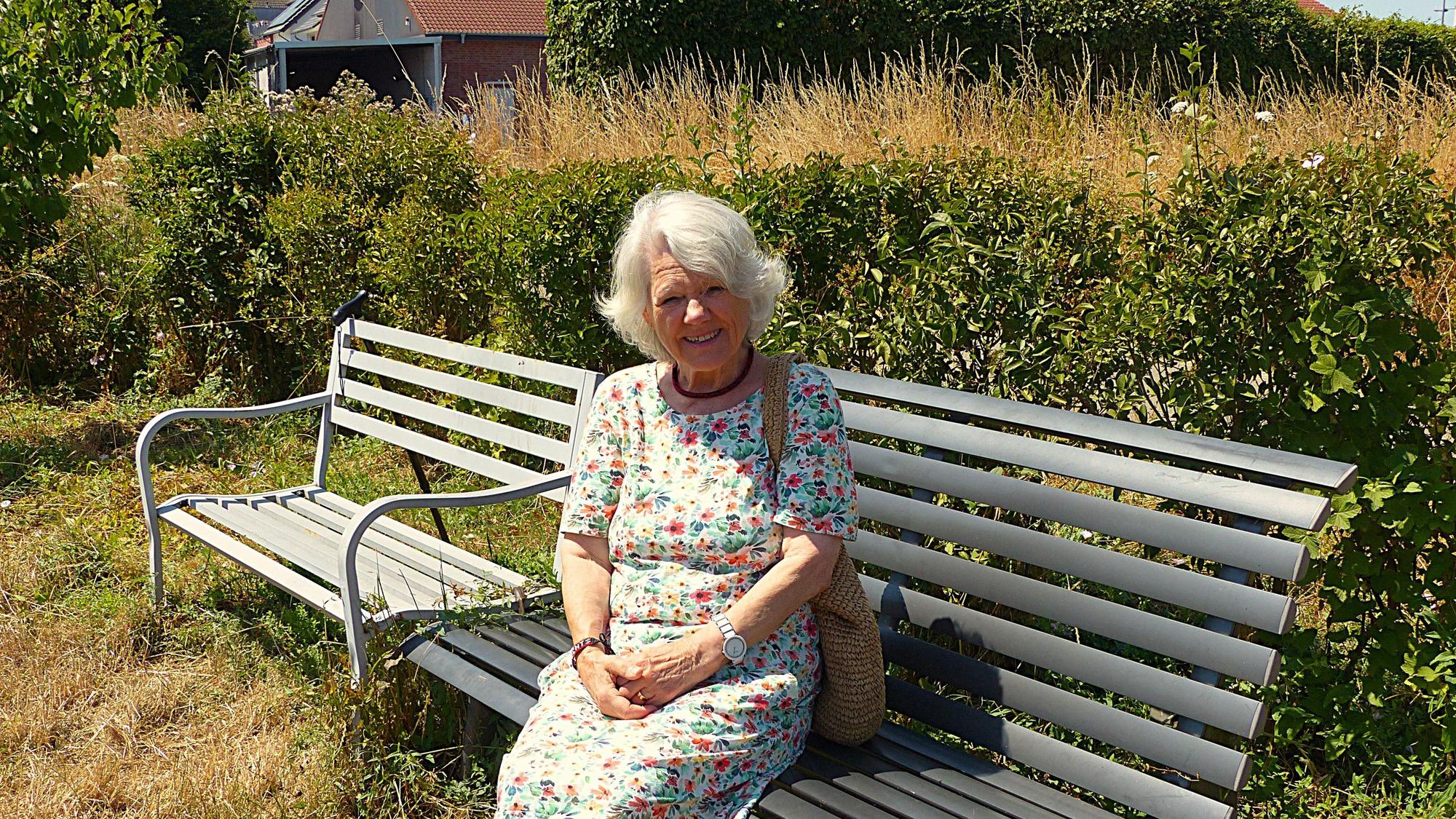 Das Foto zeigt eine Frau auf einer Bank.