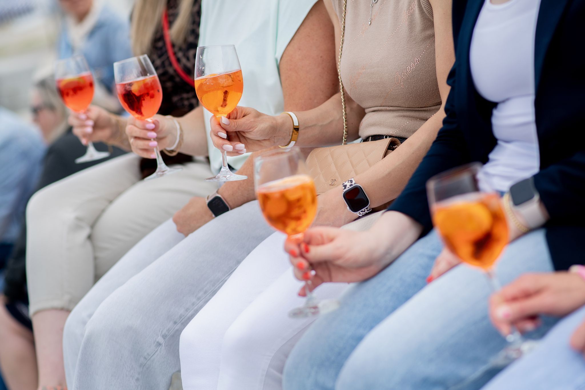 Aperol Spritz in den Händen von Personen.
