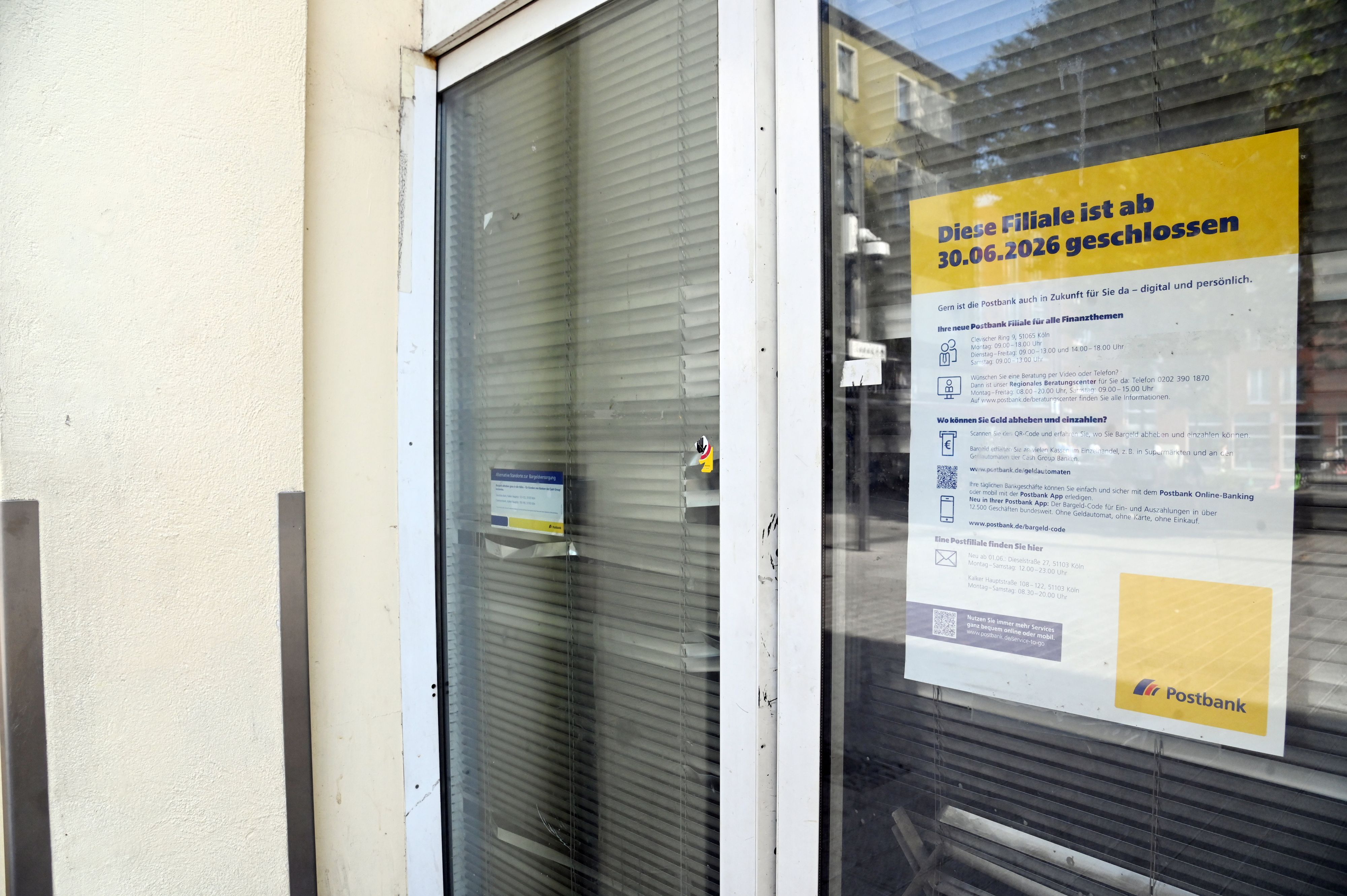 Ein Schild in einer Glaseingangstür weist darauf hin, dass die Postfiliale in Kalk geschlossen ist.