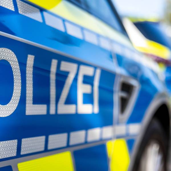 An der Tür von einem Streifenwagen steht der Schriftzug „Polizei“.