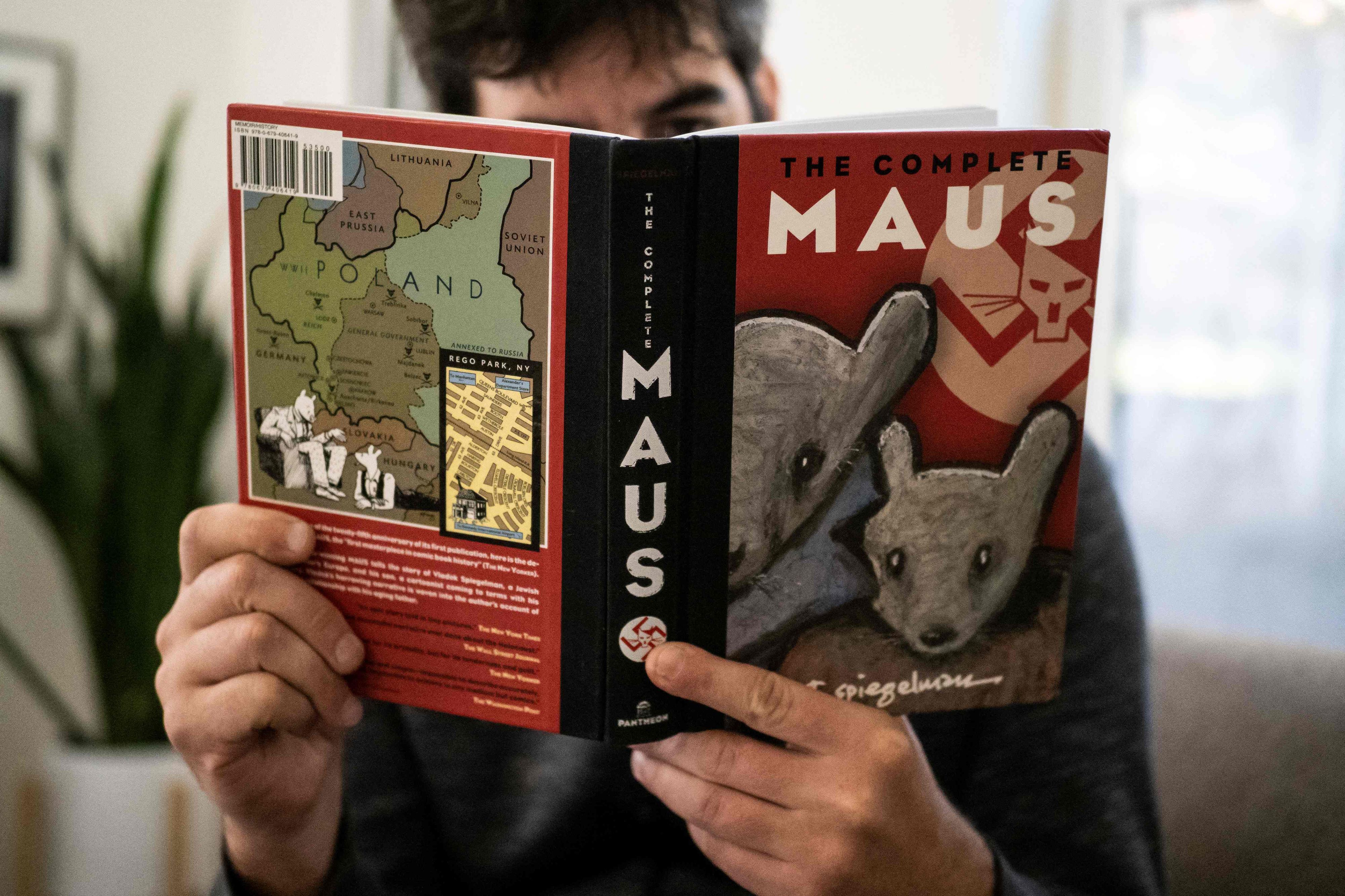 Dieses am 27. Januar 2022 in Los Angeles, Kalifornien, aufgenommene Foto zeigt eine Person, die den Comicroman „Maus“ von Art Spiegelman in der Hand hält. - Ein Schulausschuss in Tennessee hat den Anstieg der Buchverbote durch konservative Kräfte weiter angeheizt, indem er anordnete, den preisgekrönten Comicroman „Maus“ aus dem Jahr 1986 über den Holocaust aus den örtlichen Schulbibliotheken zu entfernen.