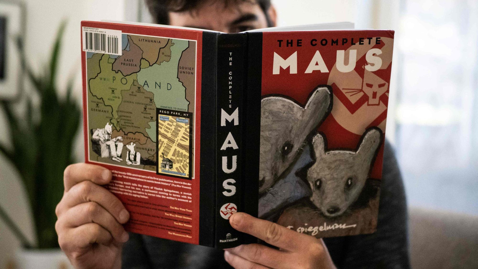 Dieses am 27. Januar 2022 in Los Angeles, Kalifornien, aufgenommene Foto zeigt eine Person, die den Comicroman „Maus“ von Art Spiegelman in der Hand hält. - Ein Schulausschuss in Tennessee hat den Anstieg der Buchverbote durch konservative Kräfte weiter angeheizt, indem er anordnete, den preisgekrönten Comicroman „Maus“ aus dem Jahr 1986 über den Holocaust aus den örtlichen Schulbibliotheken zu entfernen.