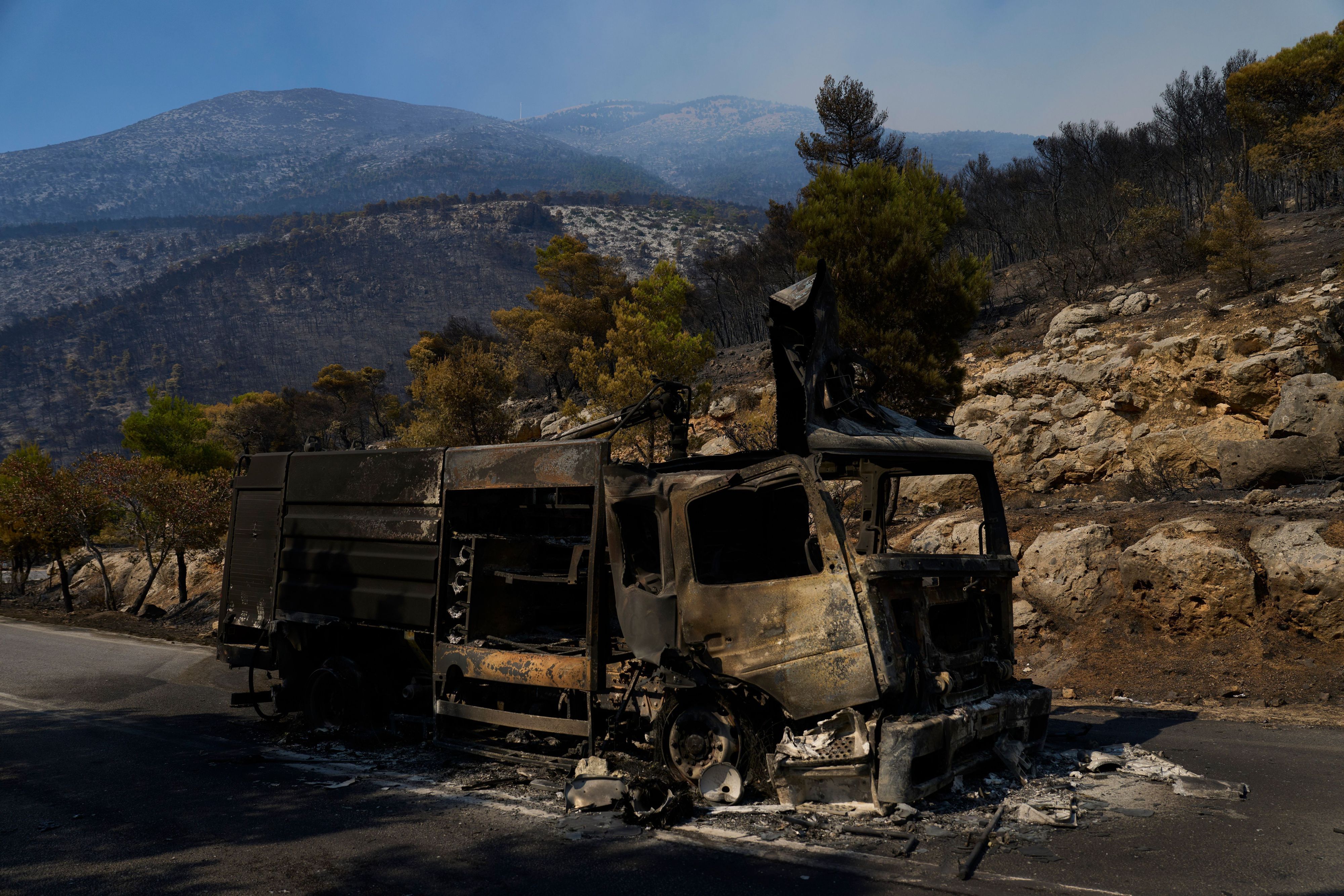 Ein durch einen Waldbrand zerstörtes Feuerwehrfahrzeug steht auf einer Straße in der Nähe von Porto Germeno, nordwestlich von Athen.