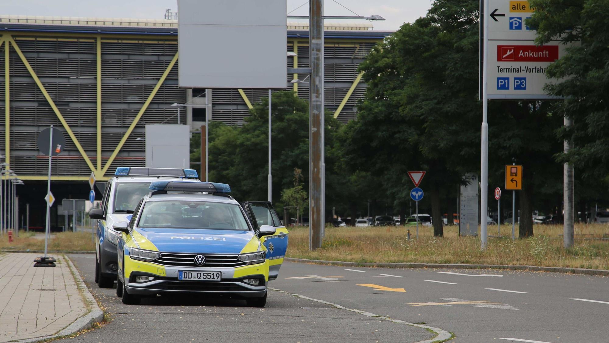 Polizeifahrzeuge stehen vor der Zufahrt der Flughafenverwaltung am Flughafen Leipzig/Halle. Der Flughafen hat in der Nacht den Flugbetrieb vorübergehend eingestellt, nachdem ein unbekanntes Flugobjekt gefunden wurde.