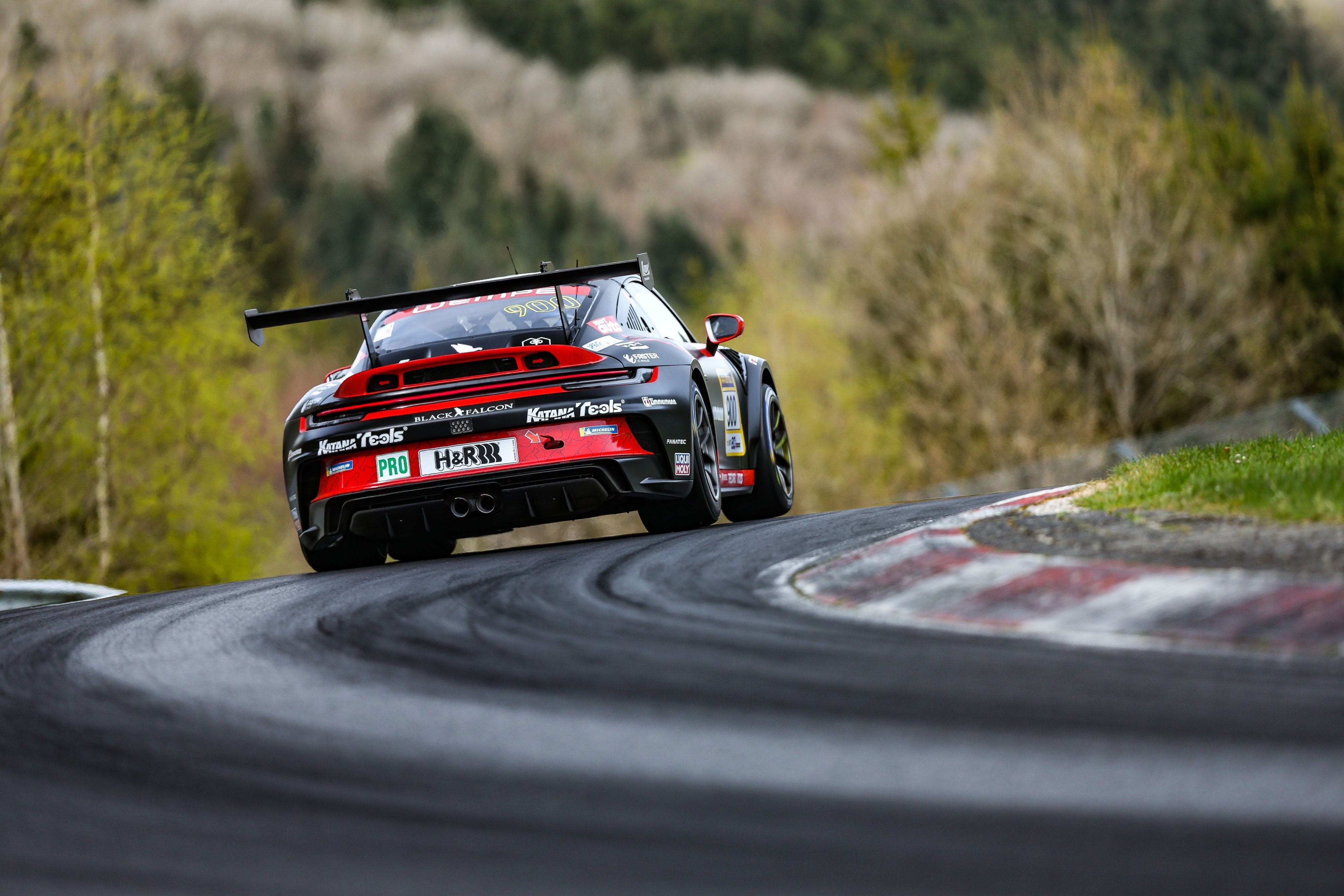 Der Porsche von Alex Hardt ist von hinten zu sehen, wie er durch eine Kurve fährt.