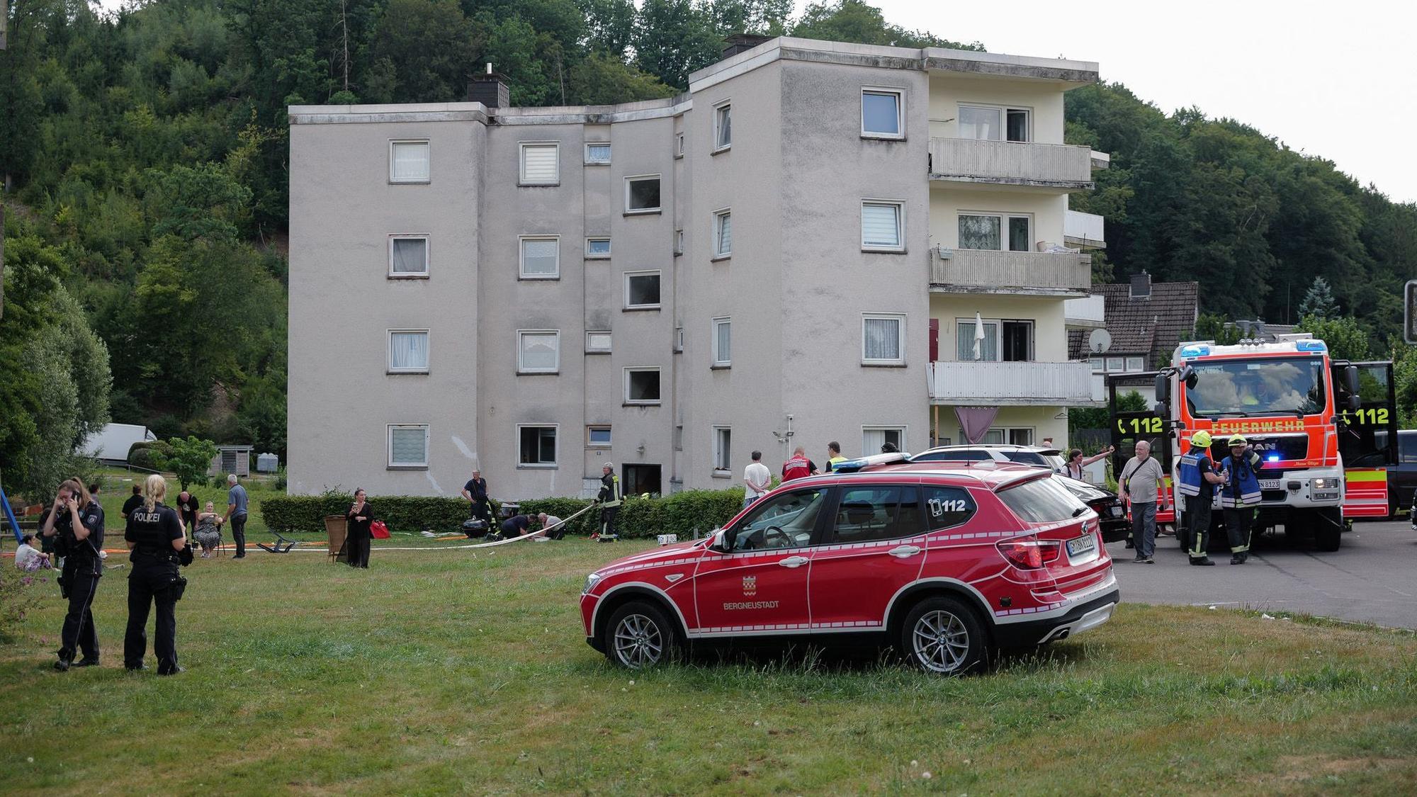 Feuerwehrautos vor einem dreigeschossigen Haus.