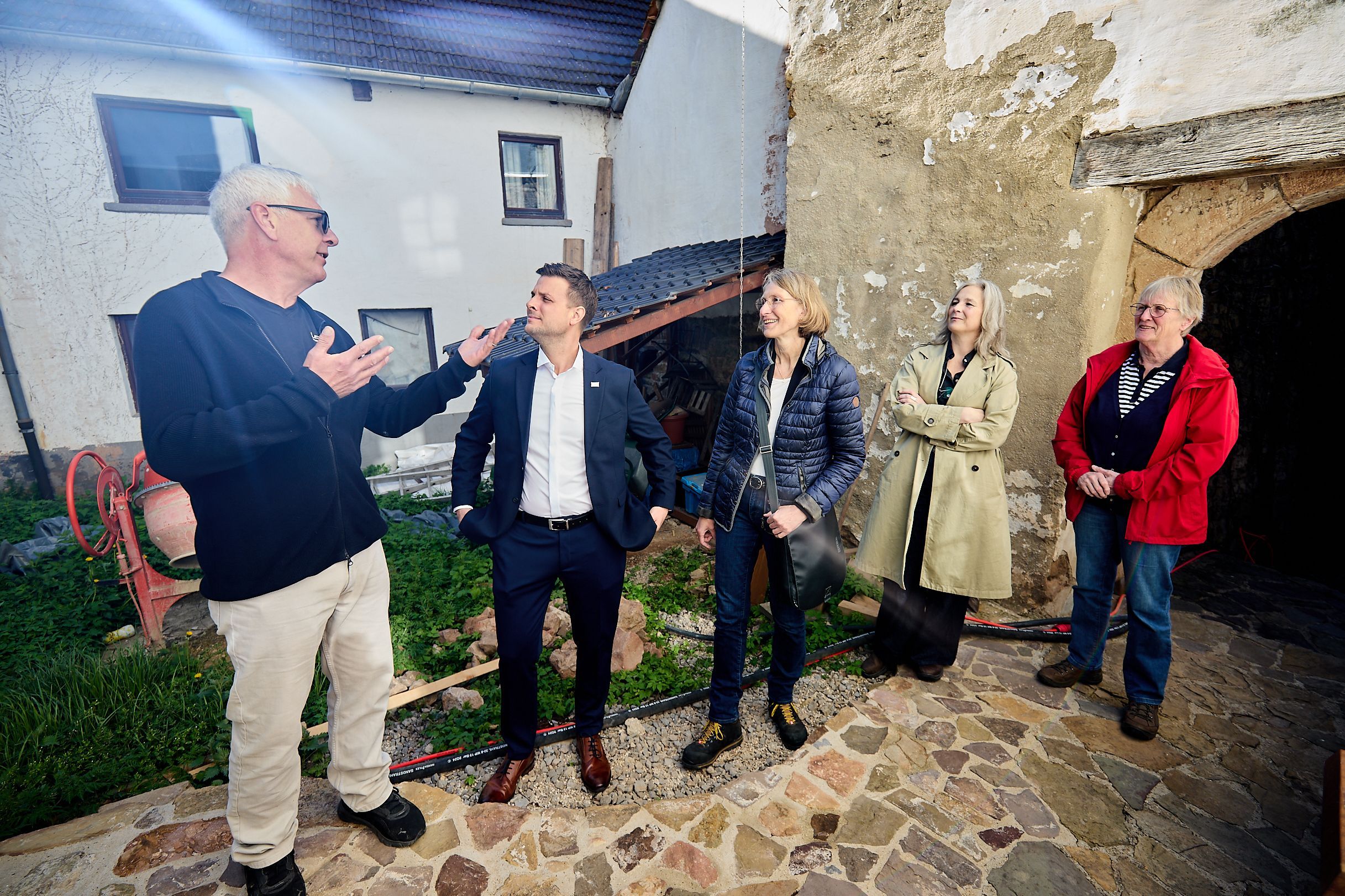 Der Burgbesitzer erläutert mit ausladenden Gesten den Besuchern etwas.