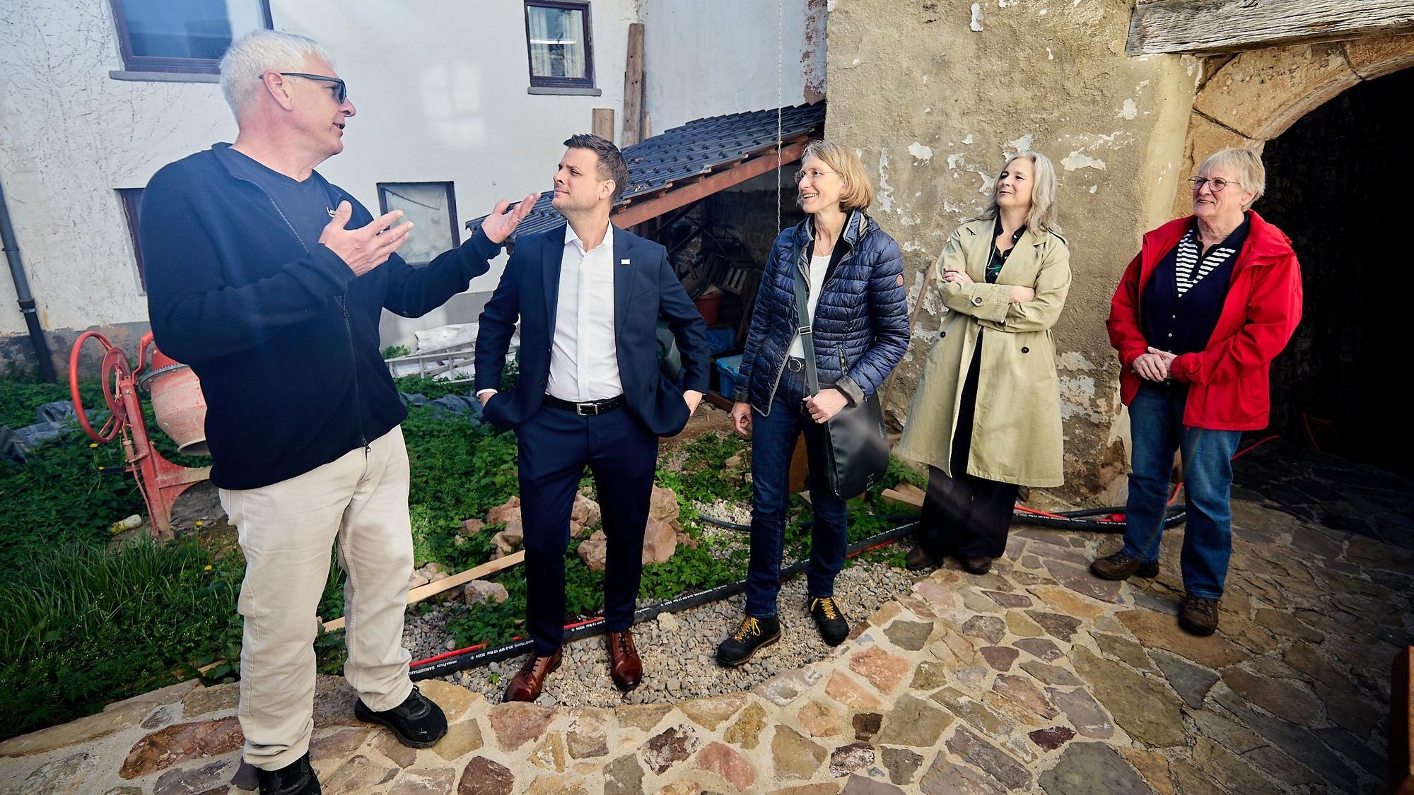 Der Burgbesitzer erläutert mit ausladenden Gesten den Besuchern etwas.