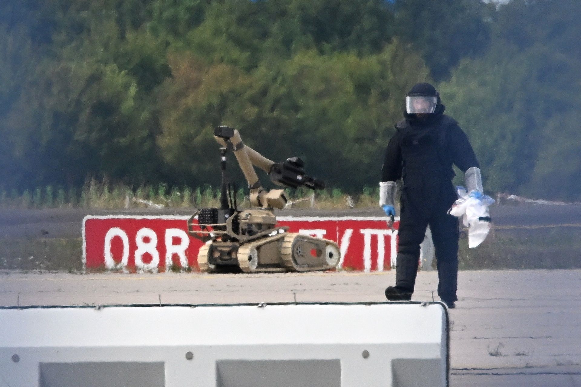 Ein Kriminaltechniker ist neben einem Sprengroboter in der Nähe eines ukrainischen Flugzeugs auf dem Flughafen Leipzig/Halle im Einsatz.