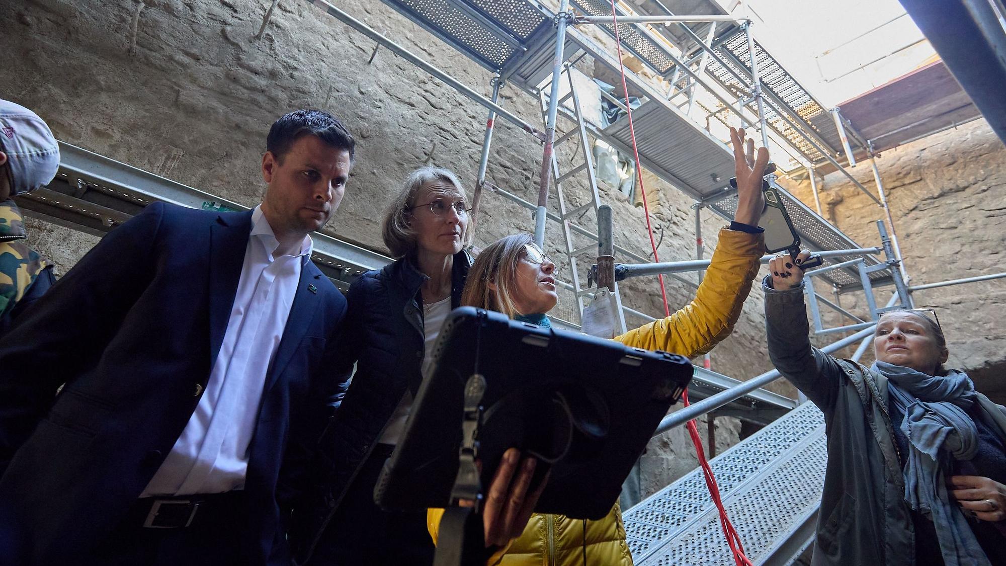 Die Expertin erklärt gestenreich Bauspuren in einer alten Burg.