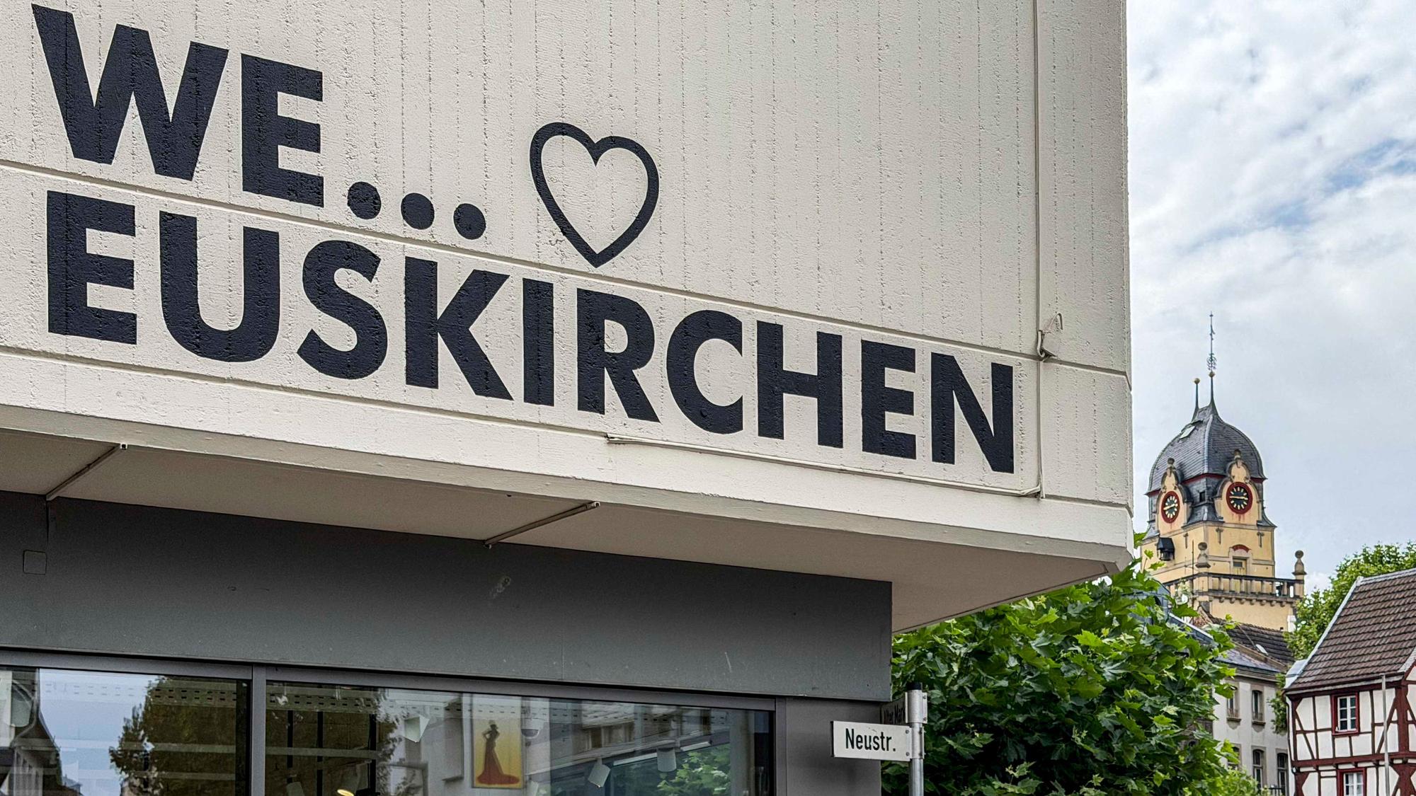 Das Bild zeigt den Aufdruck „We love Euskirchen“ auf einer Fassade. Im Hintergrund ist das Alte Rathaus zu sehen.