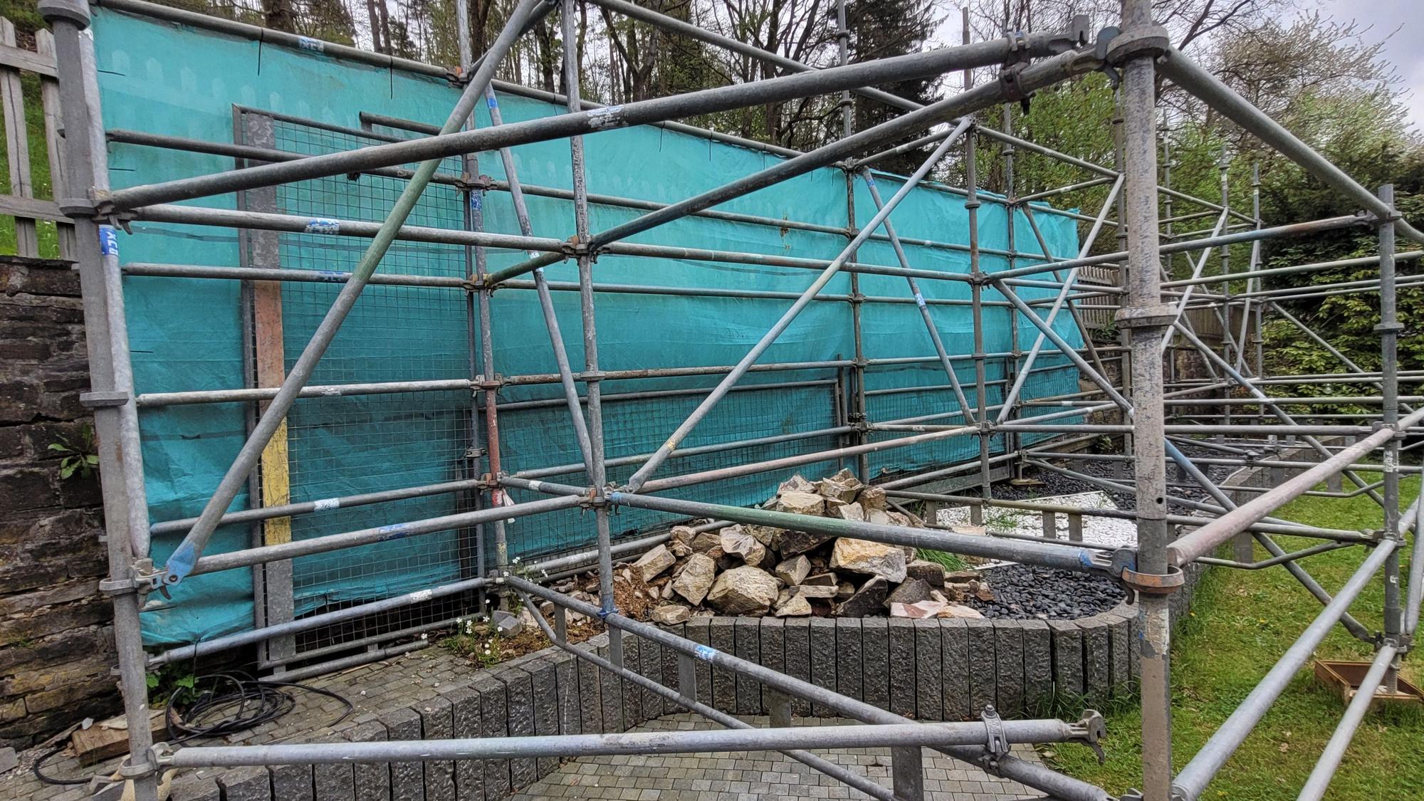 Das Foto zeigt eine mit einem Gerüst abgestützte Mauer.