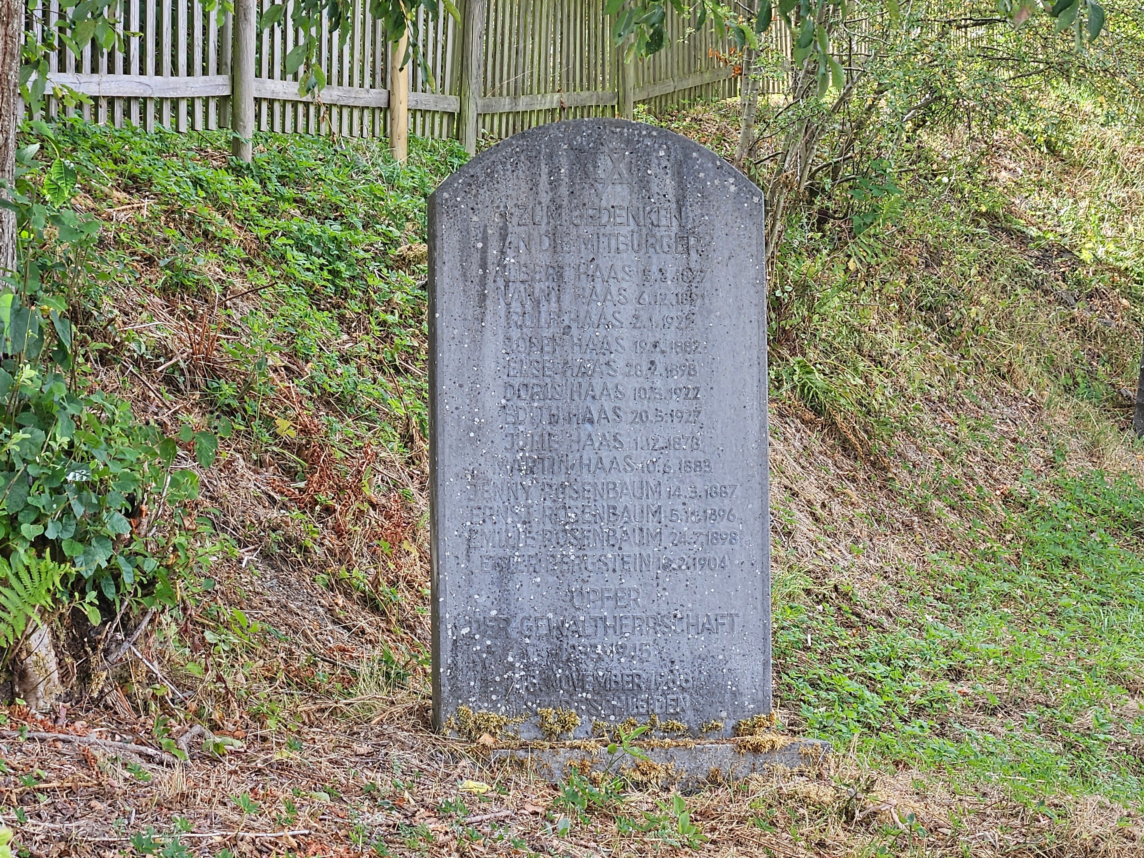 Das Foto zeigt einen Gedenkstein mit Namen und Daten darauf.