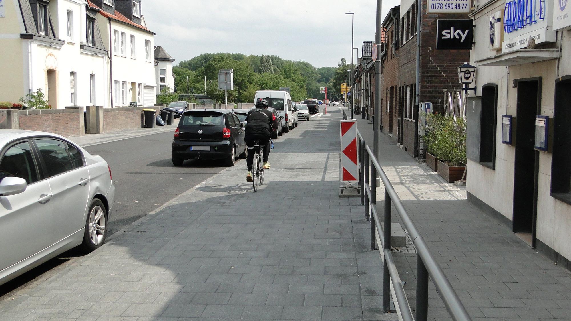 Ein Radfahrer fährt auf der Neusser Landstraße in Worringen, kurz nach Generalinstandsetzung (Abschnitt 1).