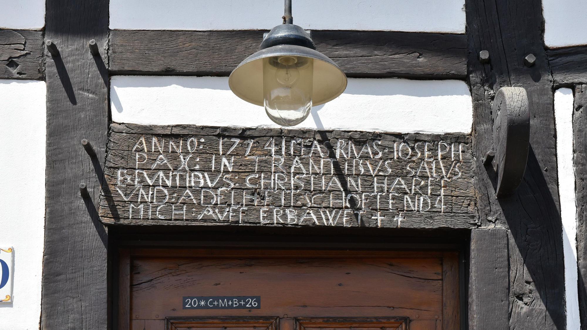 Ein alter Holzbalken aus dem Jahr 1774 mit einer Inschrift