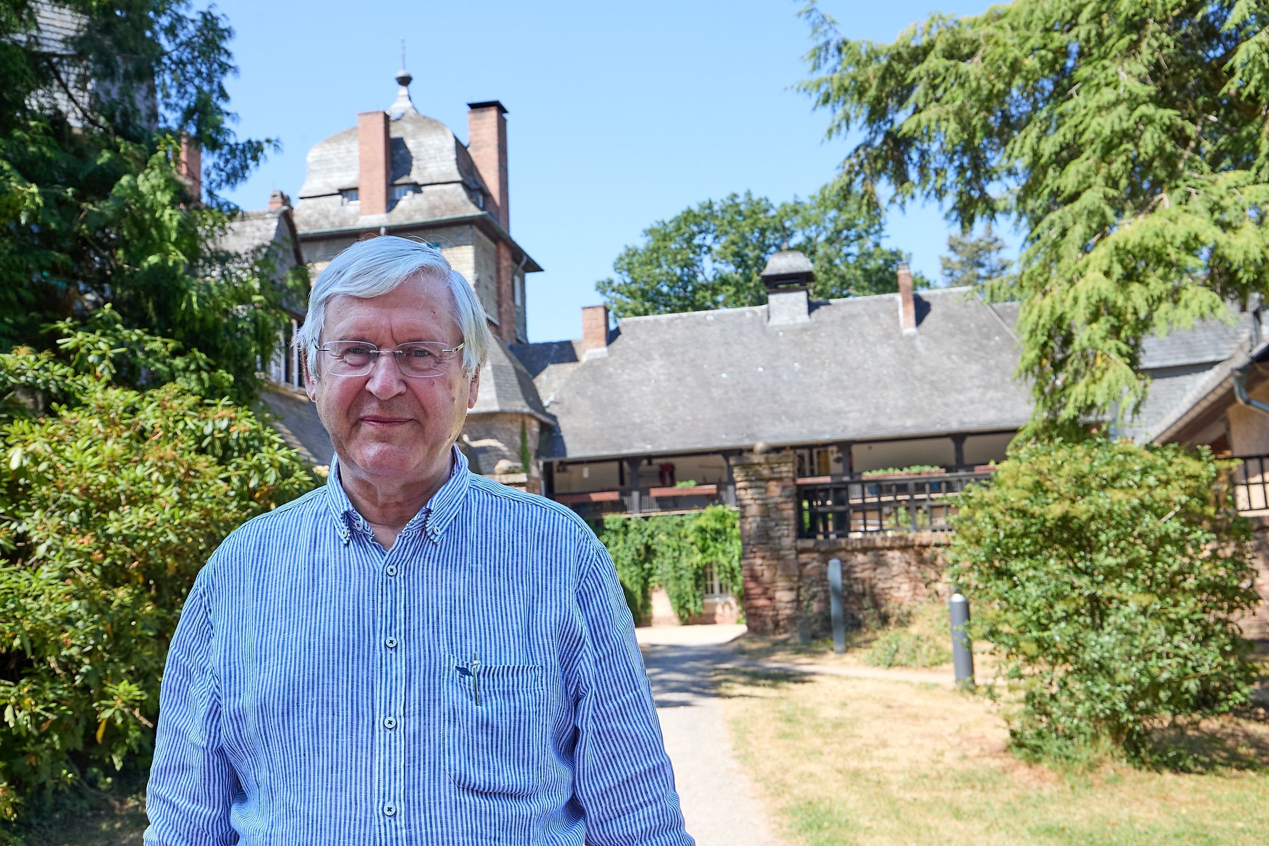 Ein Mann steht vor seinem Gutshaus im Wald bei Mechernich.