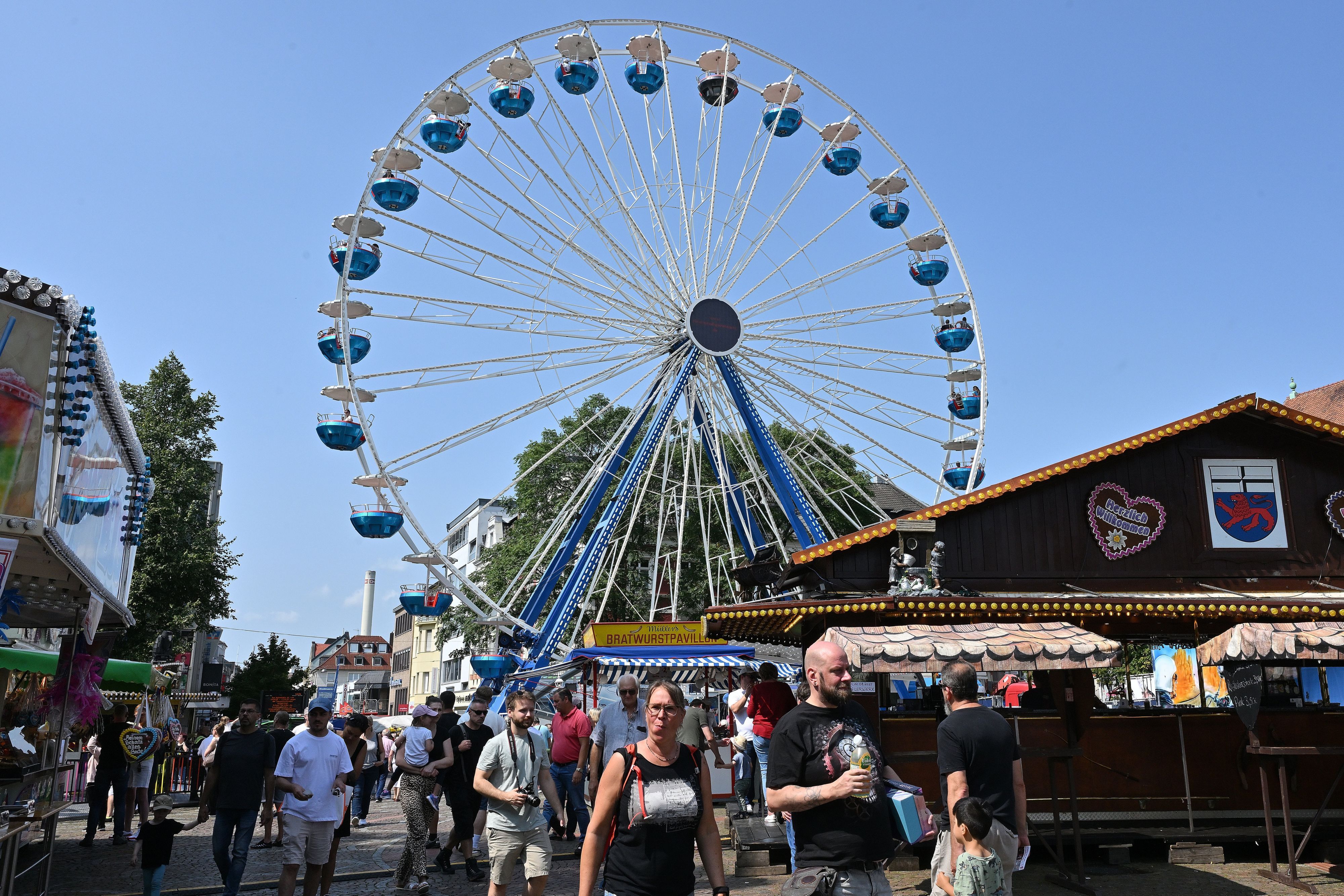 Ein Riesenrad steht in der Gladbacher Stadtmitte, davor Buden und Kirmesbesucher.