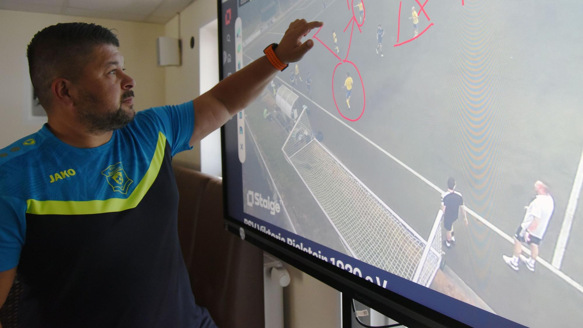 Christopher Pethe analysiert ein Fußballspiel auf einem Smartboard.