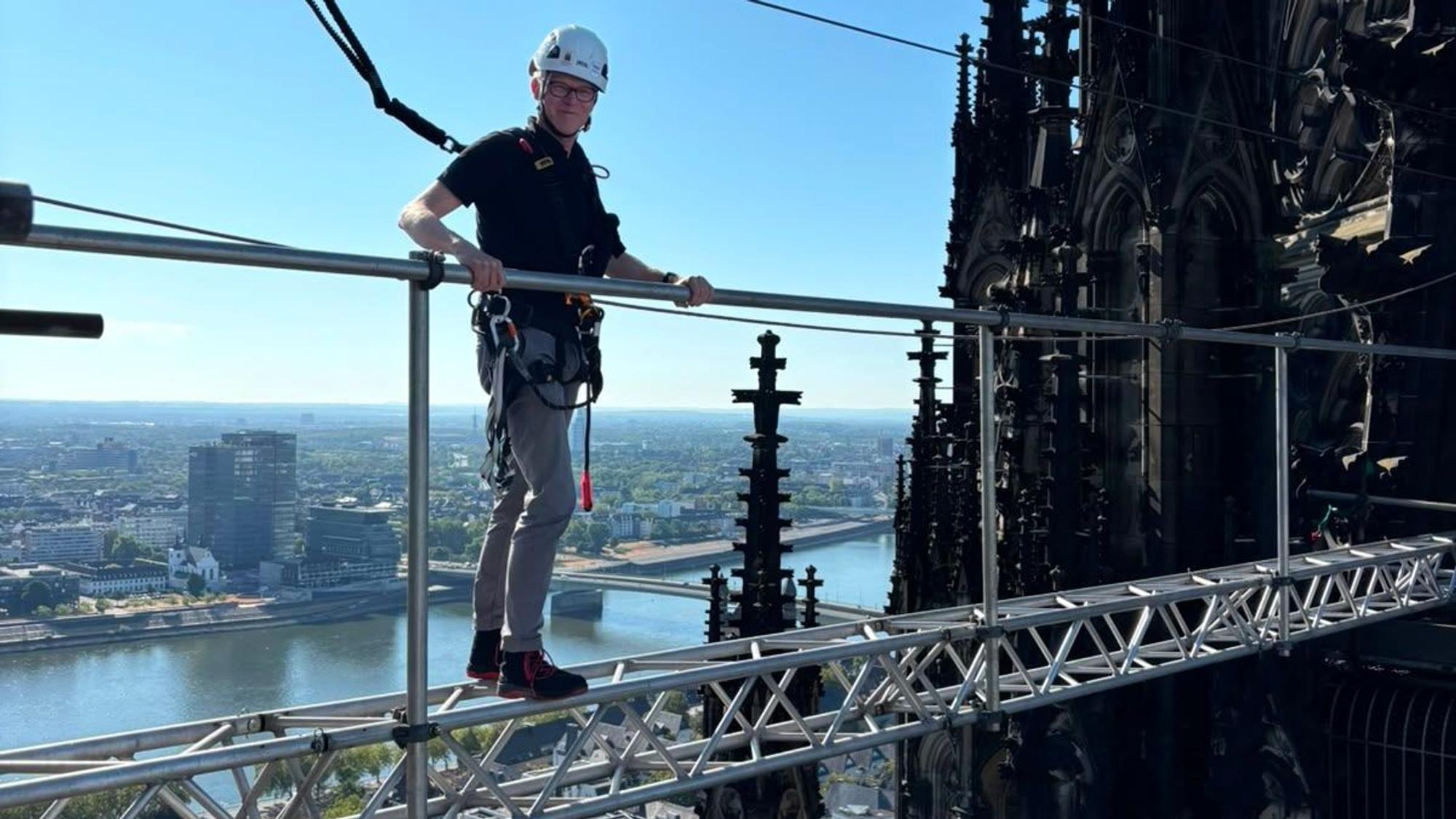 Ein Gerüstbauer auf der temporären Verbindungsbrücke zwischen den Türmen des Kölner Doms.