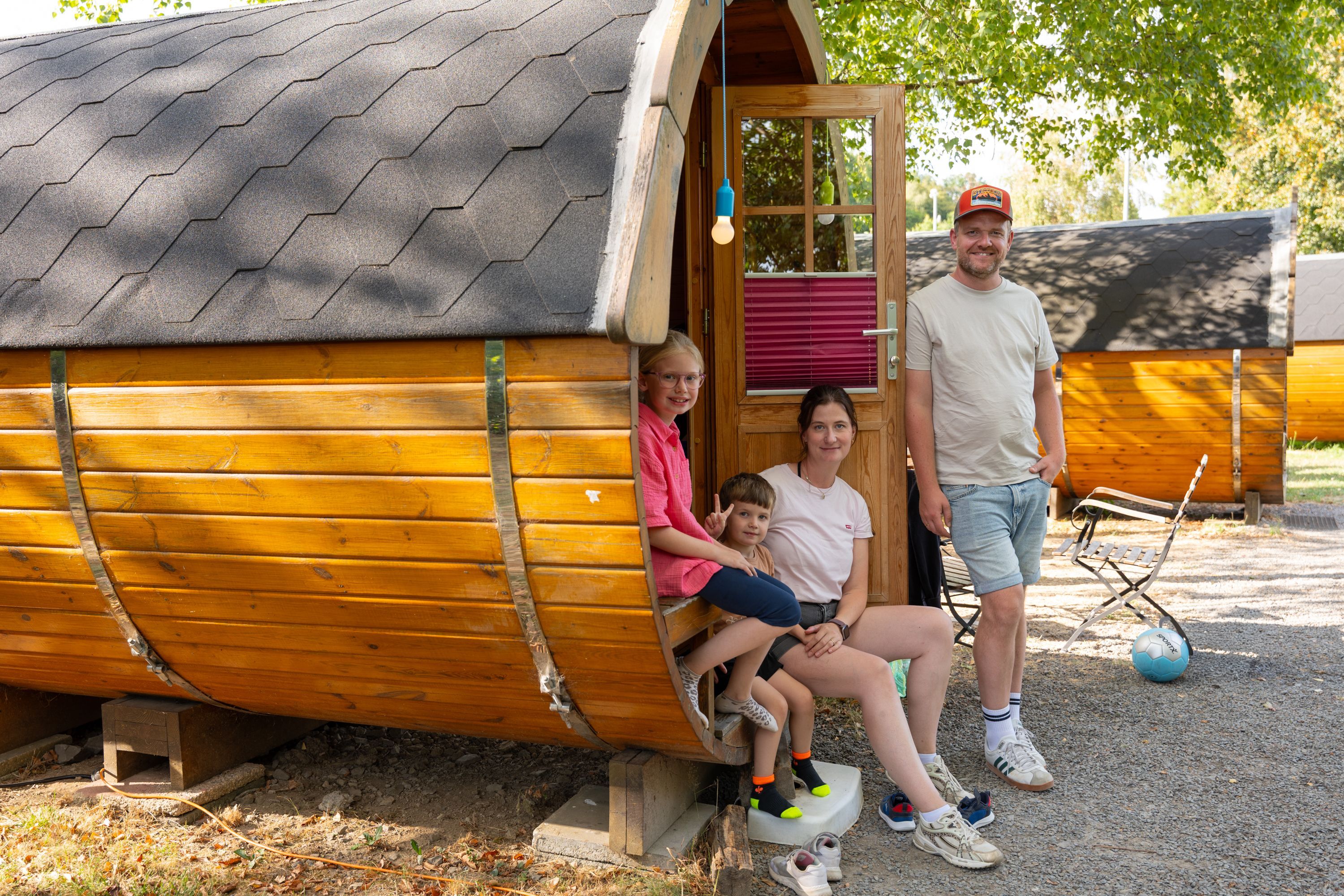 Eine Familie steht an einem Schlaf-Fass.