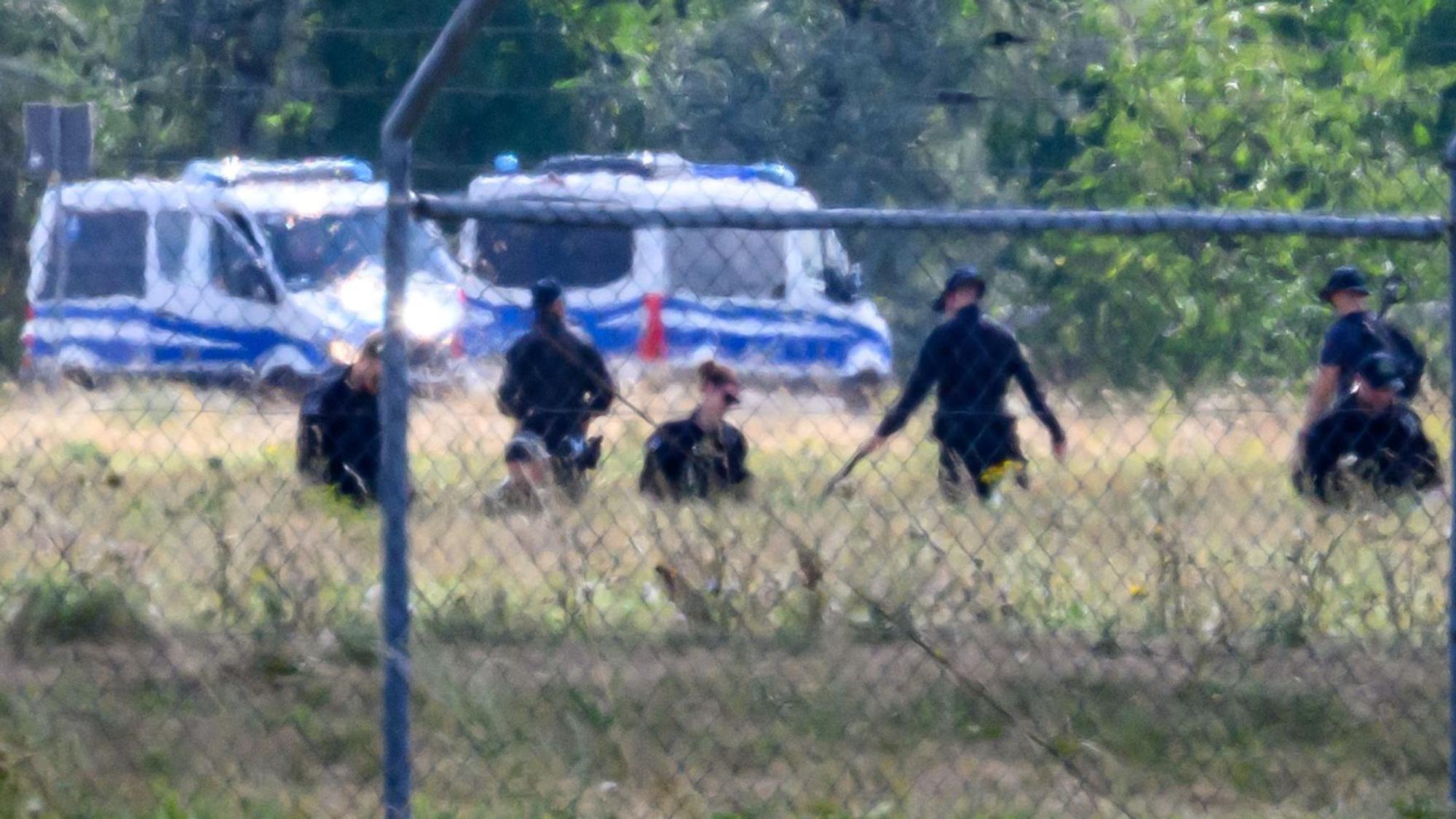 Einsatzkräfte der Polizei durchsuchen das Gelände abseits der Landebahn Nord auf dem Gelände des Flughafens Leipzig/Halle.