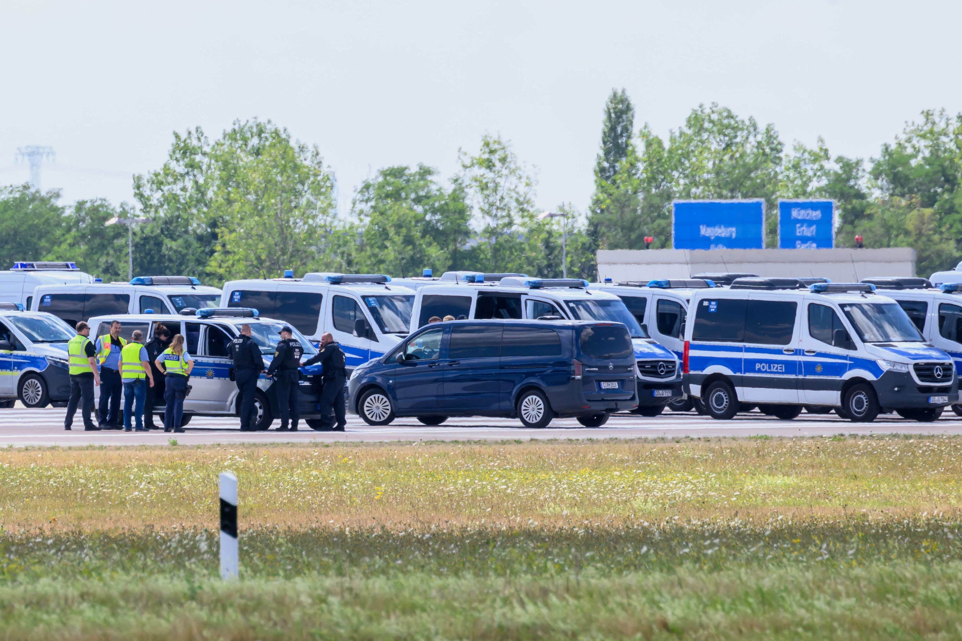 Einsatzkräfte der Polizei sind am Ende der Start-und-Lande-Bahn Nord des Flughafens Leipzig/Halle unterwegs.