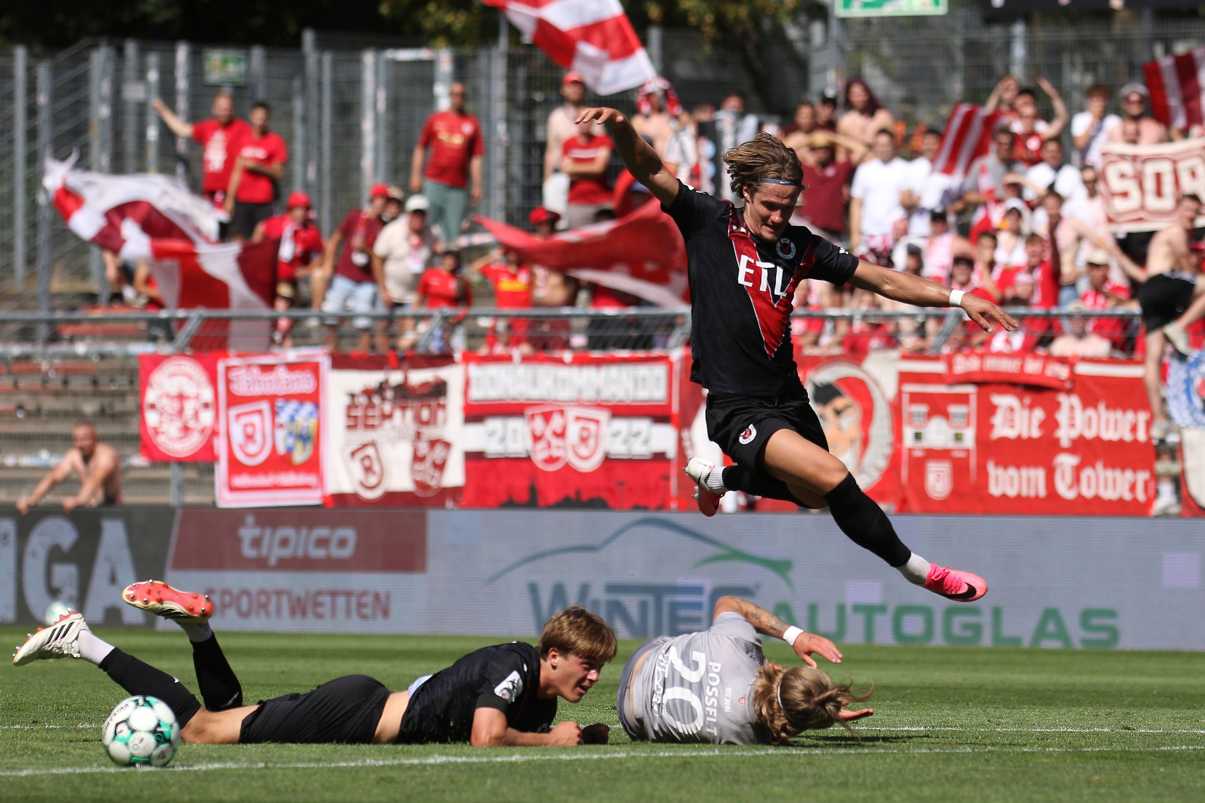 08.08.2026, xsefx, Fußball, FC Viktoria Köln SSV Jahn Regensburg, 3.Liga, Sportpark Höhenberg, 1. Spieltag, Saison 2026 2027: Tobias Eisenhuth FC Viktoria Koeln 06 springt über den am Boden liegenden John Posselt Jahn Regensburg 20 DFB regulations prohibit any use of photographs as image sequences and or quasi-video. Nordrhein-Westfalen Deutschland *** August 8, 2026, xsefx, Soccer, FC Viktoria Köln vs. SSV Jahn Regensburg, 3. Liga, Sportpark Höhenberg, Matchday 1, 20262027 Season: Tobias Eisenhuth of FC Viktoria Köln 06 jumps over John Posselt of Jahn Regensburg, who is lying on the ground. DFB regulations prohibit any use of photographs as image sequences and/or quasi-video. North Rhine-Westphalia, Germany