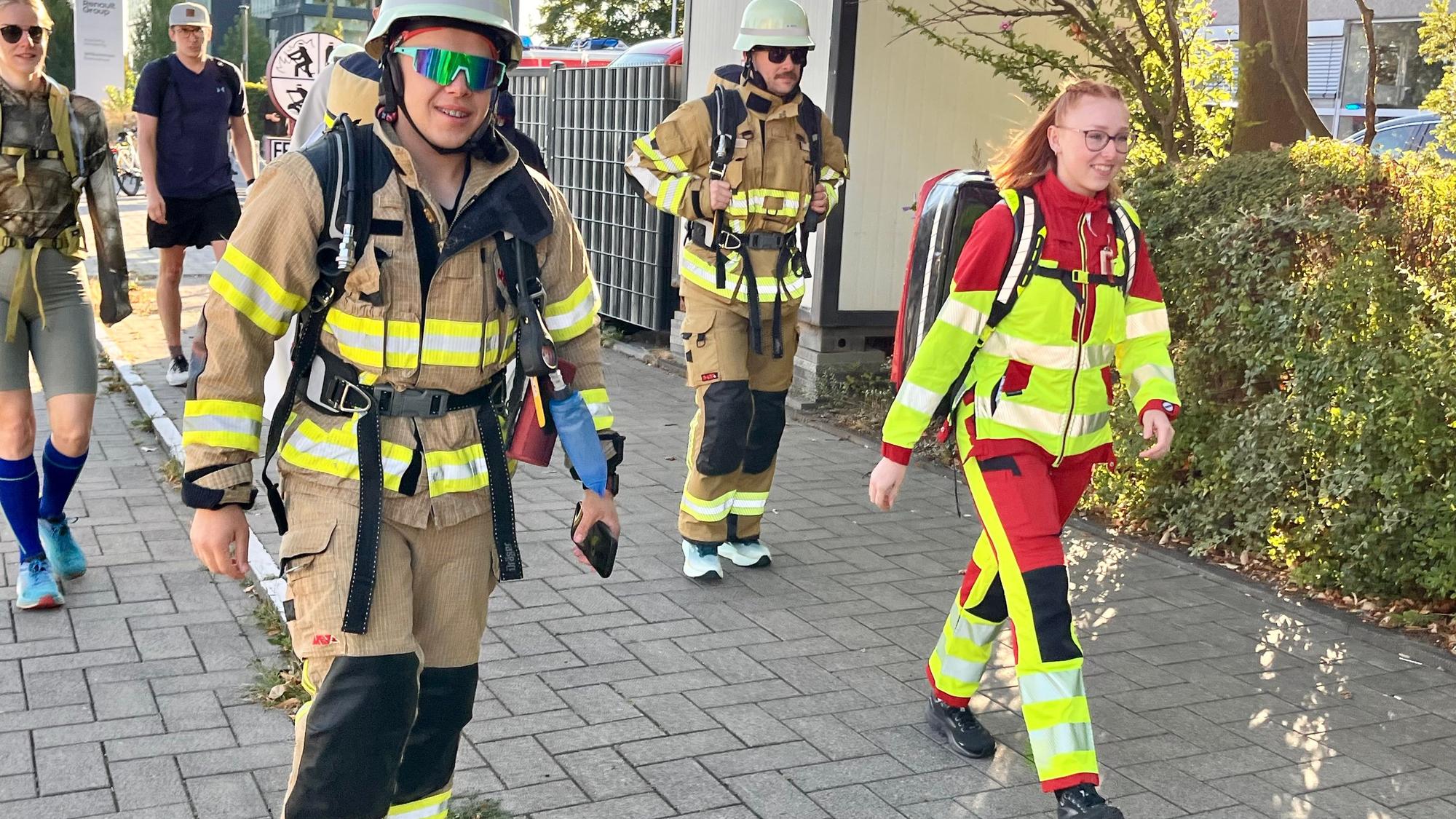 Feuerwehrleute in voller Montur machen sich auf den Weg.