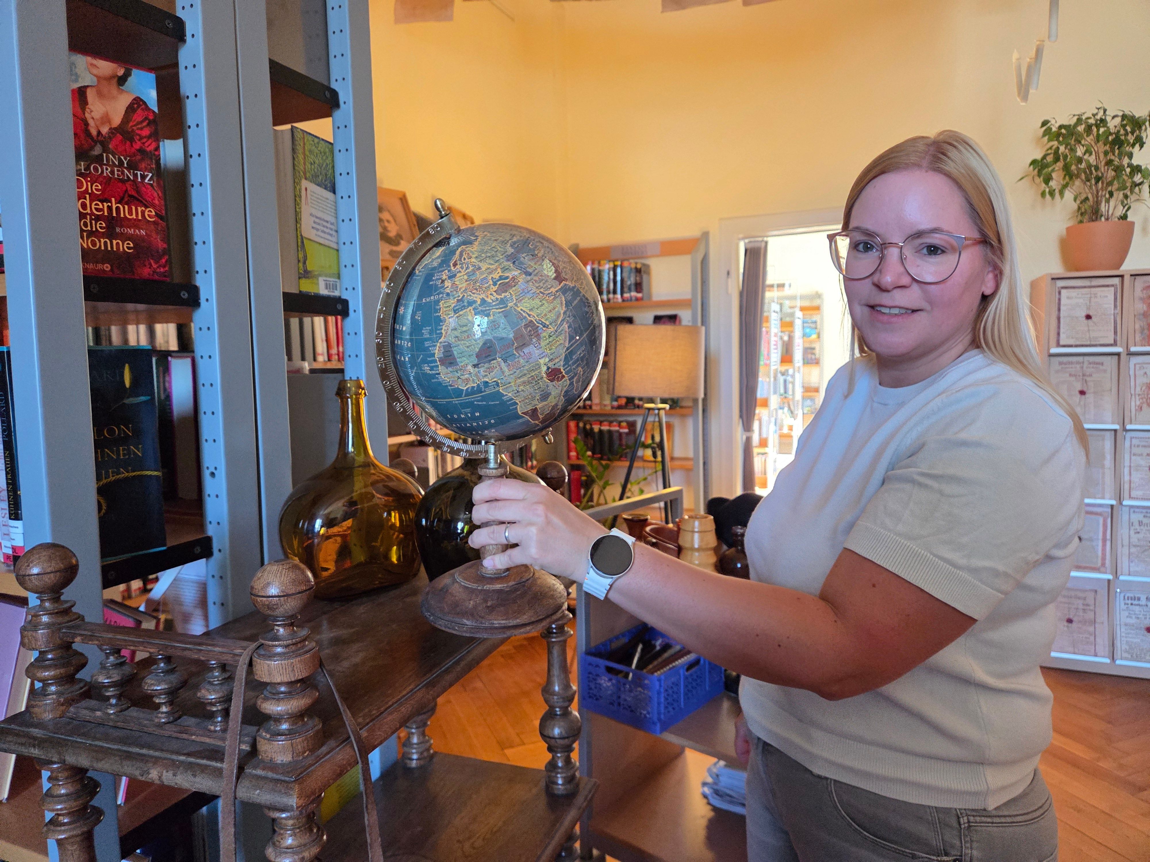 Mit viel Liebe zum Detail bekommt jedes Requisit in Waldbröls Stadtbücherei den passenden Platz: Jaqueline Gomer aus dem Leitungs-Duo arbeitet an der Kulisse für den „Escape Room". Dieser öffnet am heutigen Dienstag, 11. August 2026.