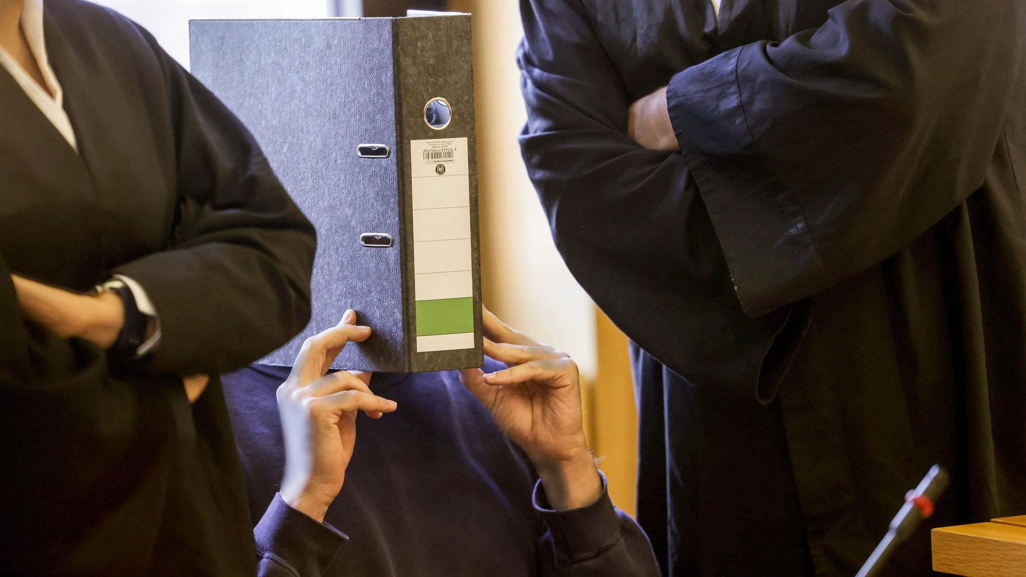 Ulrich S. im vergangenen Jahr mit einem Aktenordner vor dem Gesicht im Aachener Gerichtssaal.