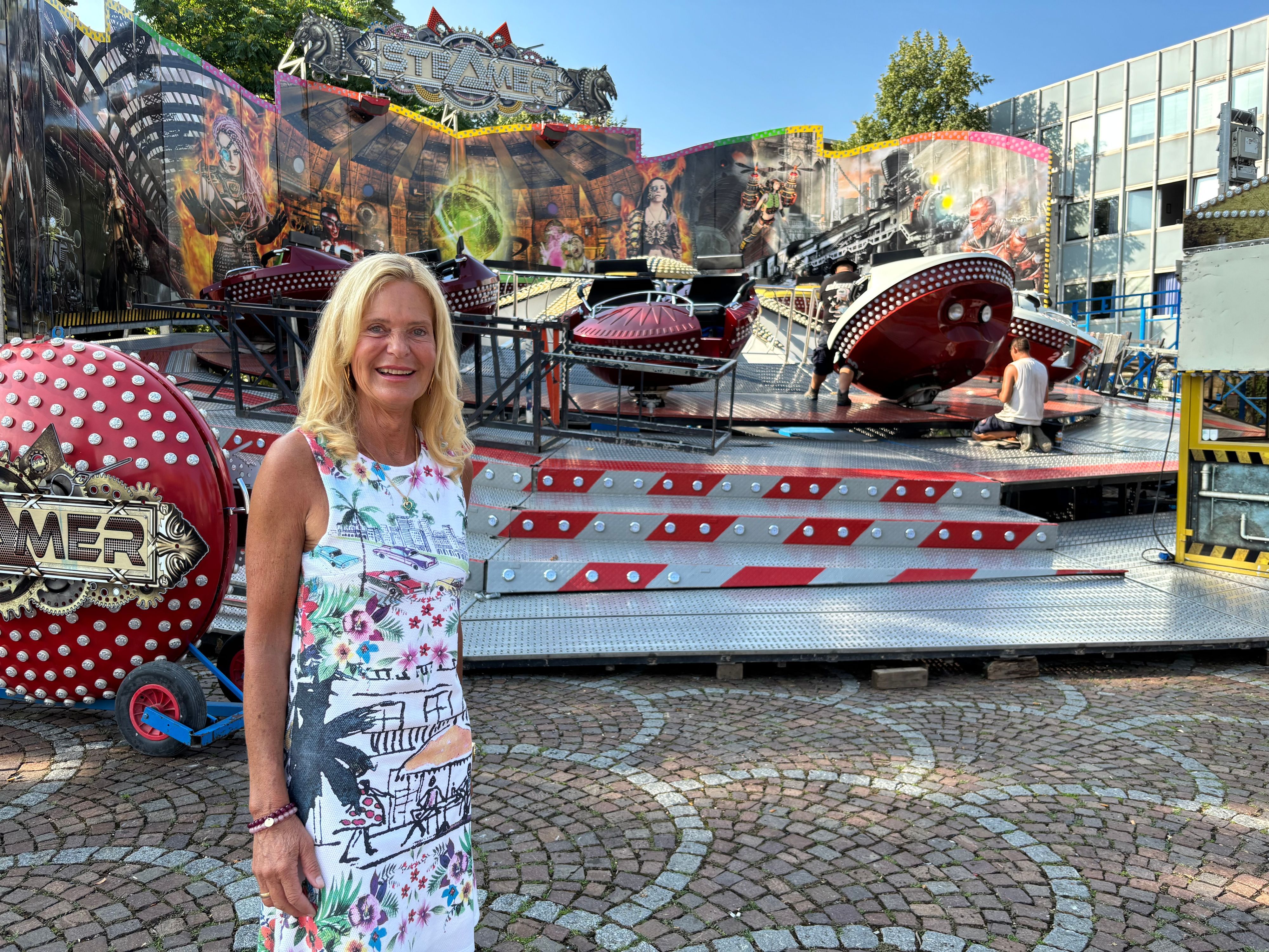 Ute Unrau steht vor einem Fahrgeschäft auf der Bergisch Gladbacher Laurentiuskirmes 2026.