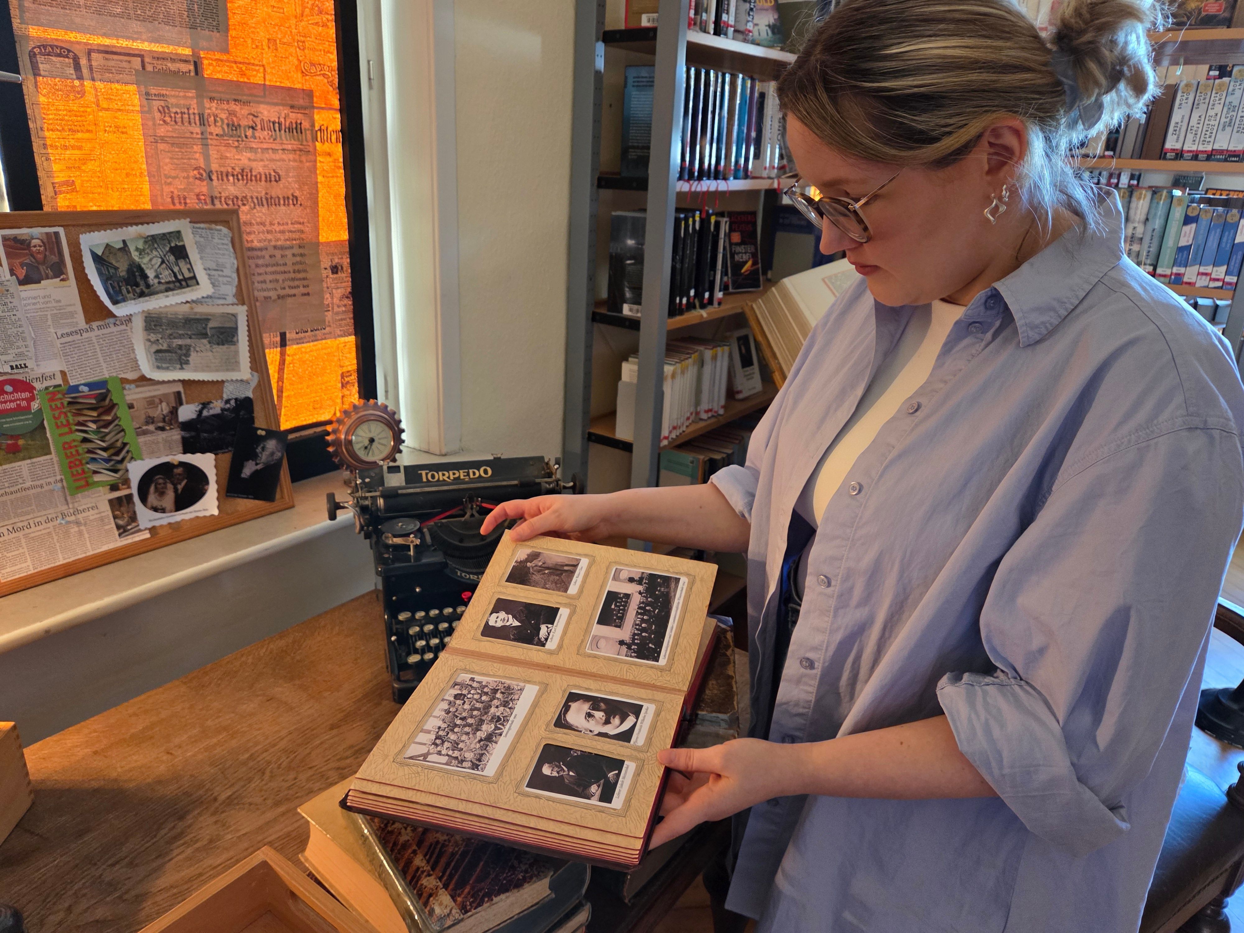 Aus dem Waldbröler Stadtarchiv stammen historische Fotografien, die Hinweise bergen können. Carolin Peters aus dem Leitungsteam der Stadtbücherei blättert in einem der Alben.