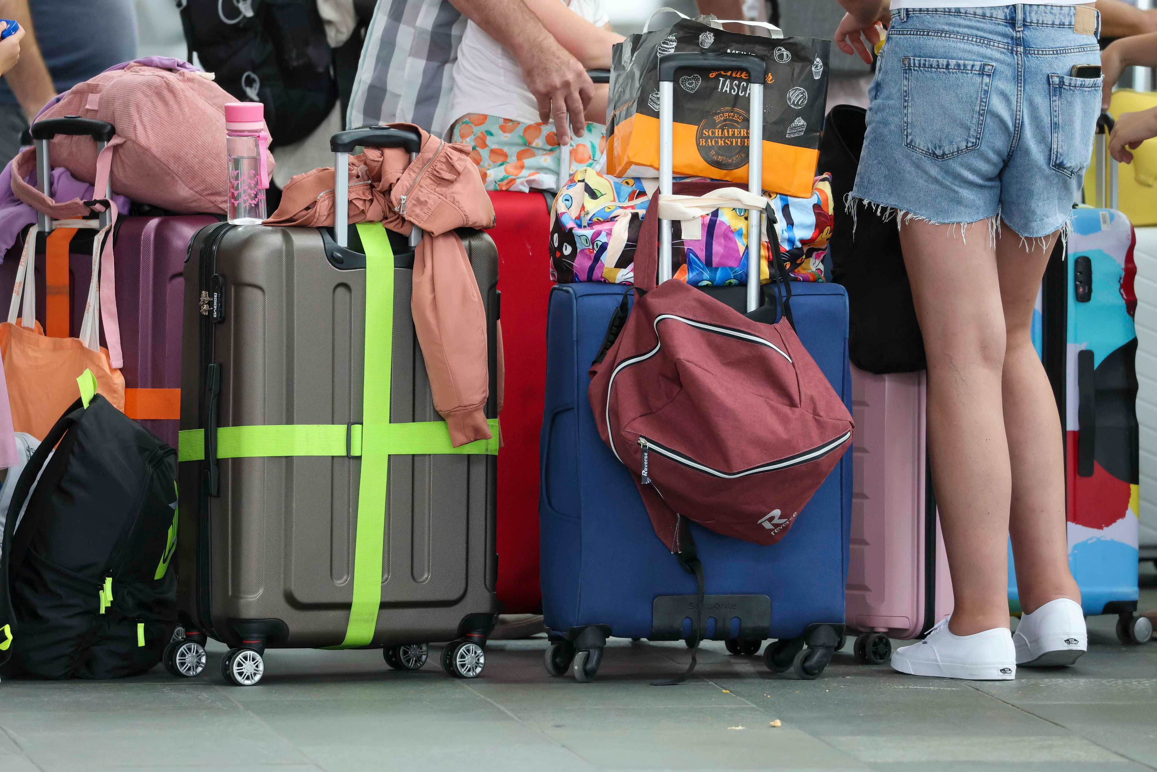 Flugreisende mit Kindern warten mit ihren Koffern am Check-In im Flughafen Leipzig-Halle. (Symbolfoto)