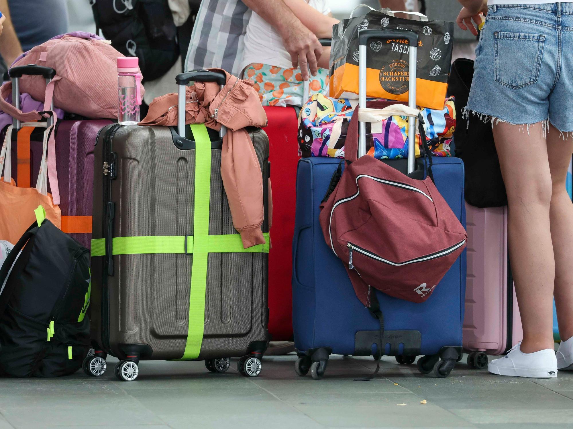 Flugreisende mit Kindern warten mit ihren Koffern am Check-In im Flughafen Leipzig-Halle. (Symbolfoto)