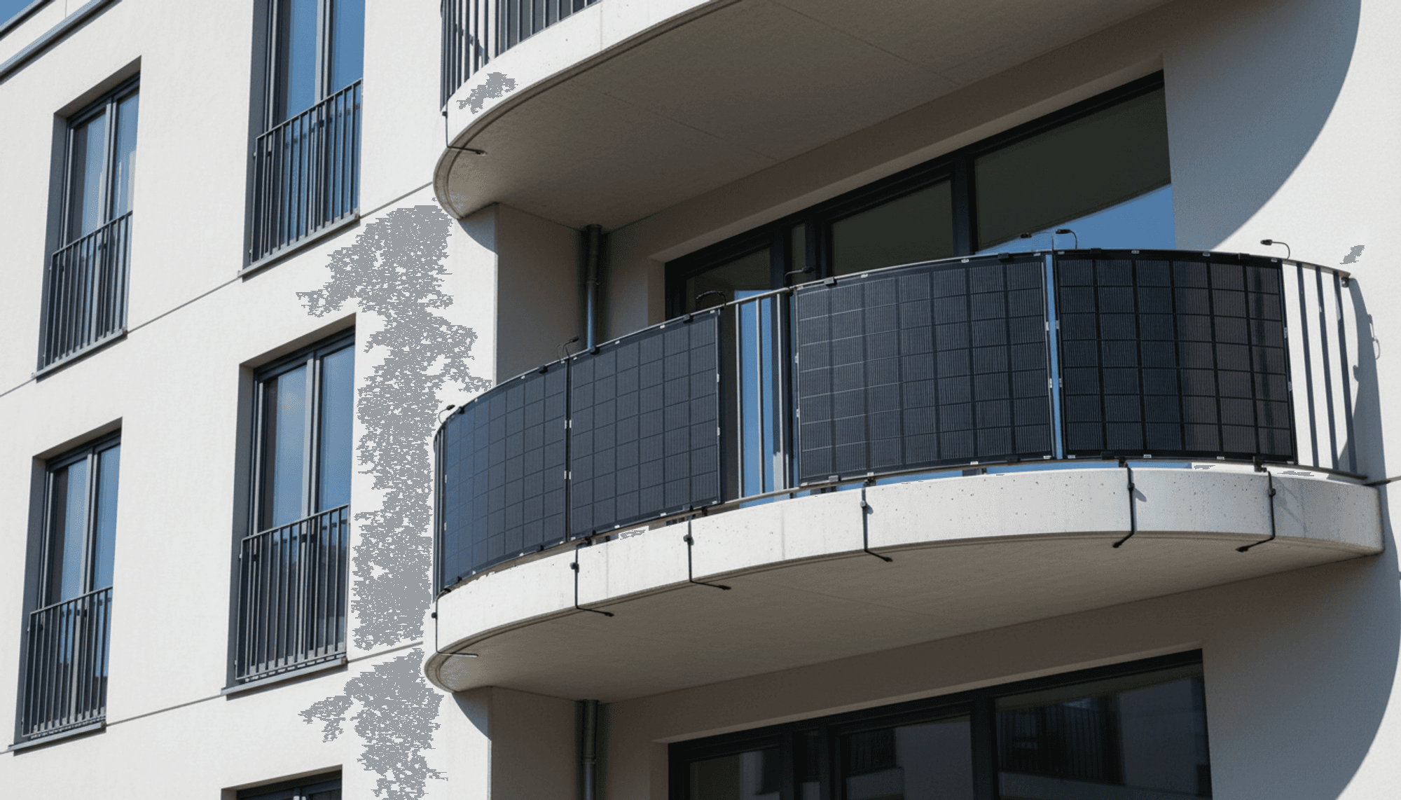 Flexible Solarmodule am geschwungenen Balkongeländer eines Mehrfamilienhauses, rahmenlose dunkle Panels an einem Balkongeländer angebracht.