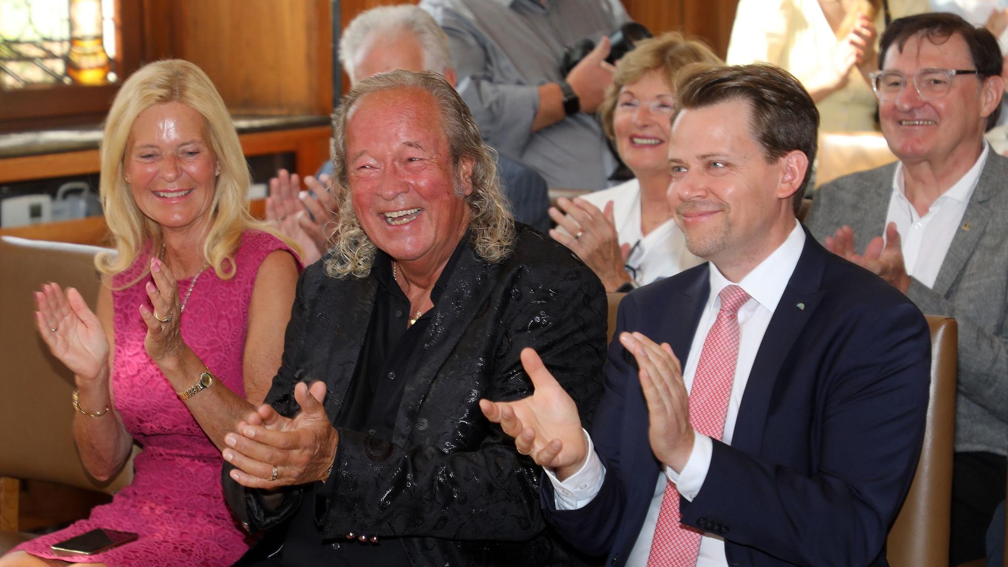 Burkhardt Unrau applaudiert mit seiner Ehefrau Ute und Landrat Arne von Boetticher dem spontanen Laudator Wolfgang Bosbach.