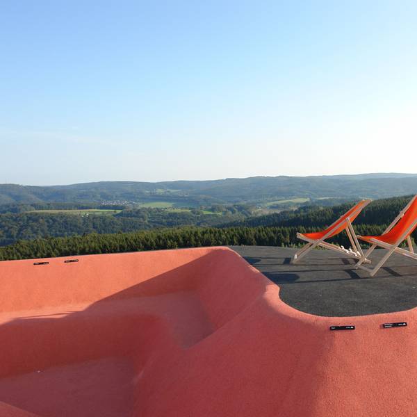 Zwei Liegenstühle vor Panorama.