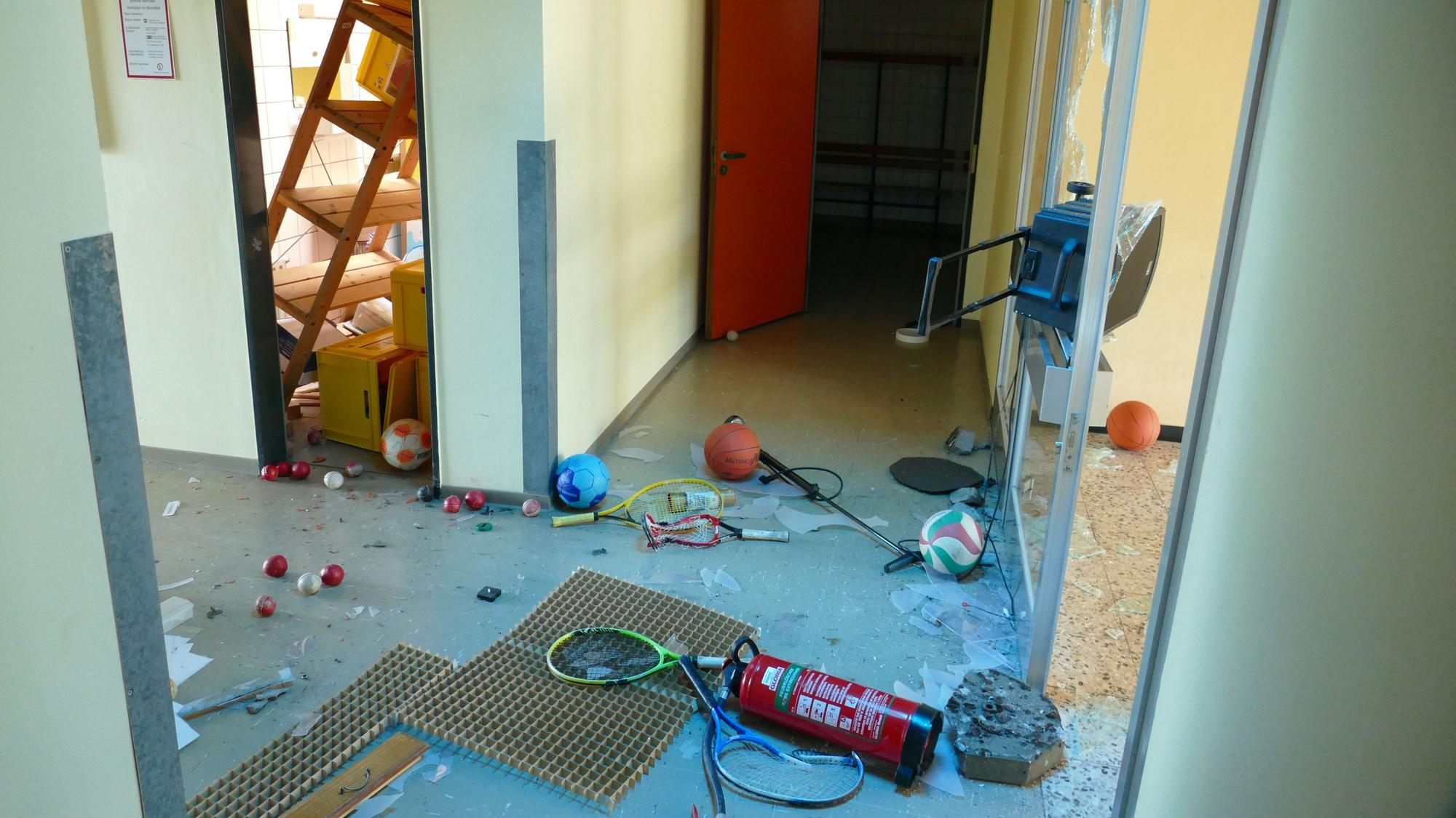 Spuren der Zerstörung in Räumen einer Schule. Am Boden liegt ein Feuerlöscher, in einem Nebenraum ist ein Regal umgekippt.