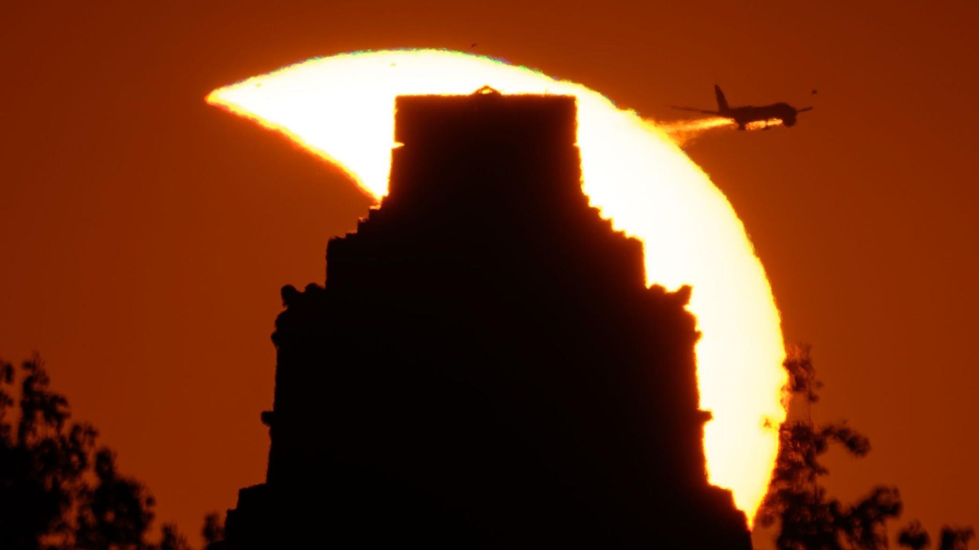 Leipzig: Die Spitze des Völkerschlachtdenkmals ragt vor der partiellen Sonnenfinsternis über den Horizont.
