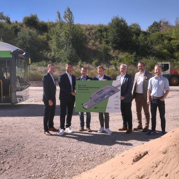 Neben einem Bus stehen (v.l.) Heiko Iffland (Geschäftsführer Ingenion), Michael Fingel (Bürgermeister Stadt Mechernich), Dr. Marcel Frank (Geschäftsführer RVK), Markus Ramers (Landrat Kreis Euskirchen), Achim Blindert (Allg. Vertreter des Landrates Kreis Euskirchen), Thomas Hambach (Beigeordneter, Stadt Mechernich), Matthias Mohr (Anlagentechnik, RVK) und halten gemeinsam ein Plakat.