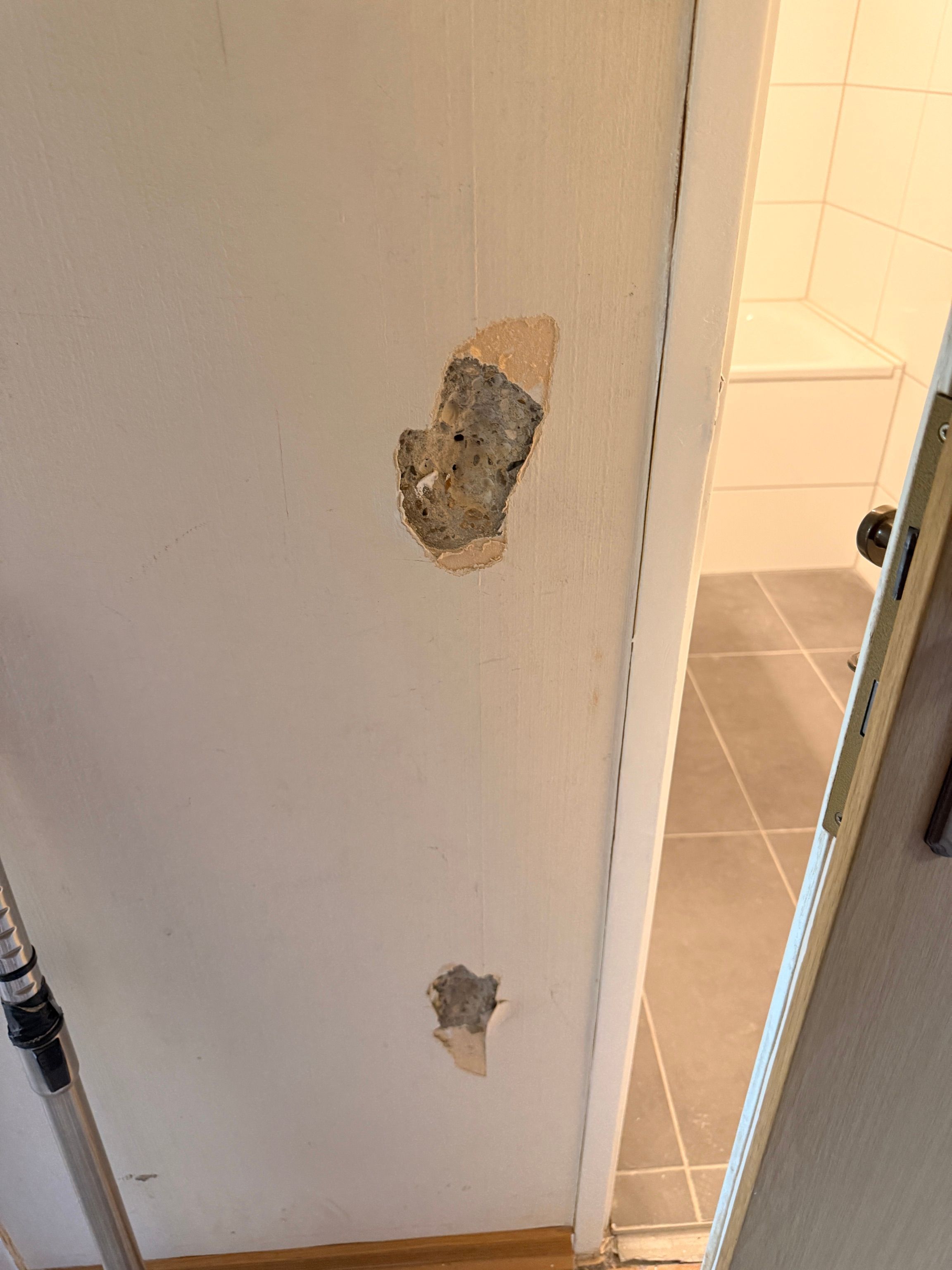 Ein faustgroßes Loch in einer verputzten Wand.