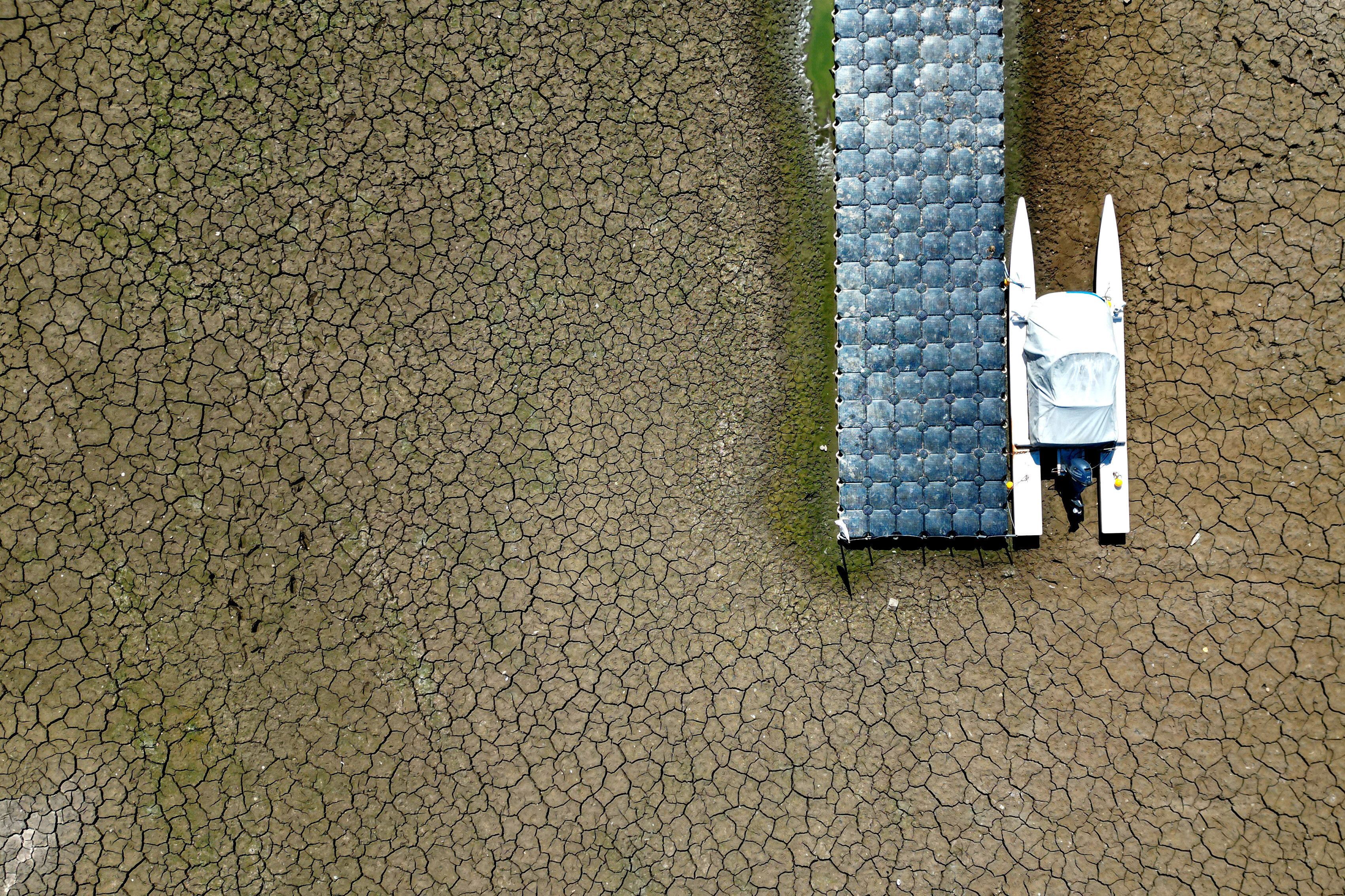 Ein Boot liegt in einem wegen des niedrigen Wasserstands im Rhein trocken gefallenen Hafenbecken in Düsseldorf. Die Pegelstände am Rhein bewegen sich weiterhin auf historisch niedrigem Niveau.