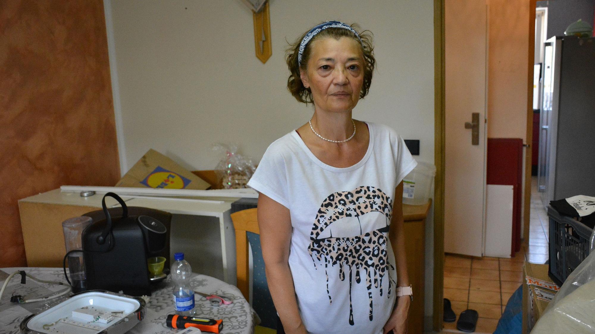 Eine Frau steht inmitten von Umzugsgut.