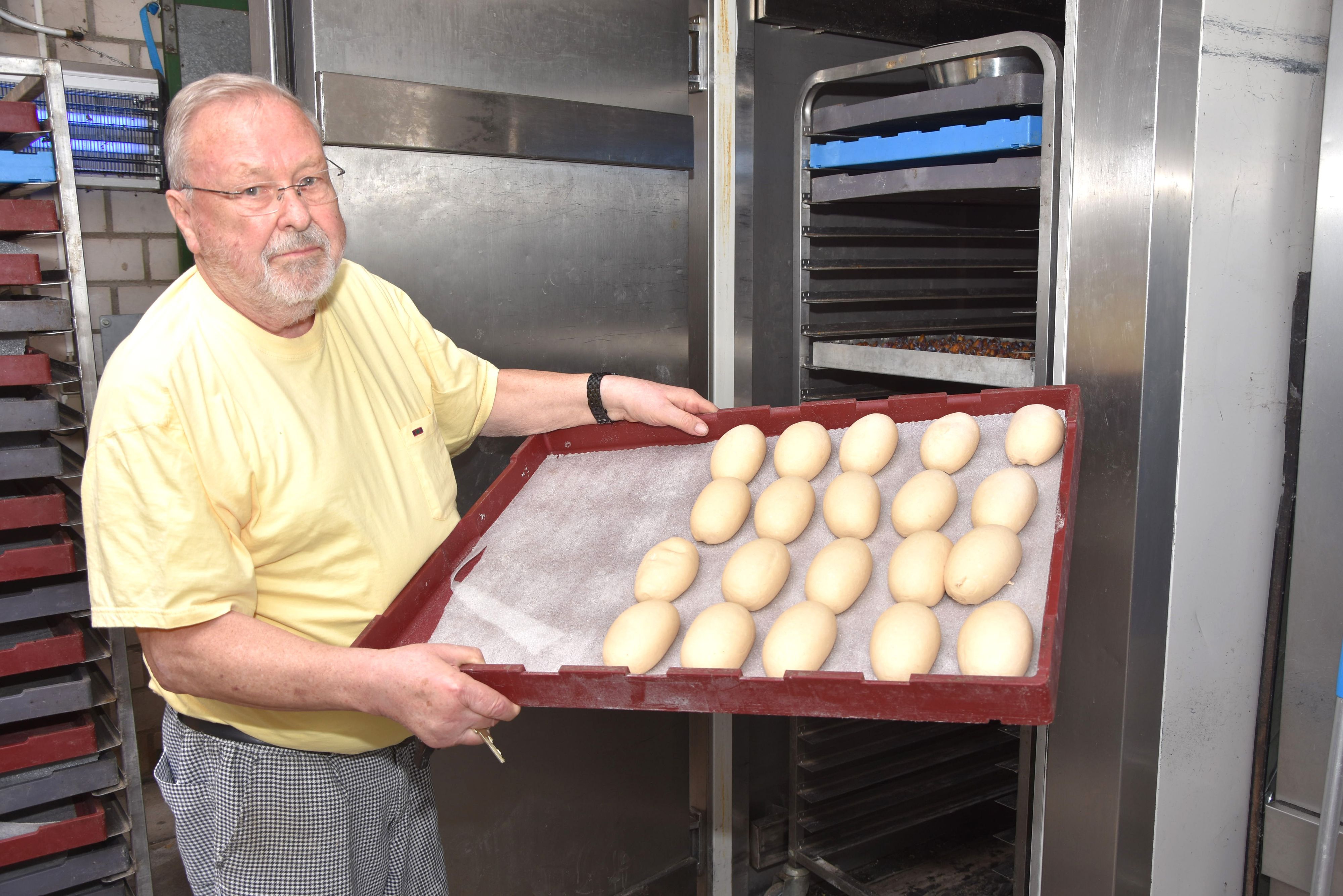 Das Bild zeigt Bäckermeister Willi Immerath mit einem Blech Brötchen.
